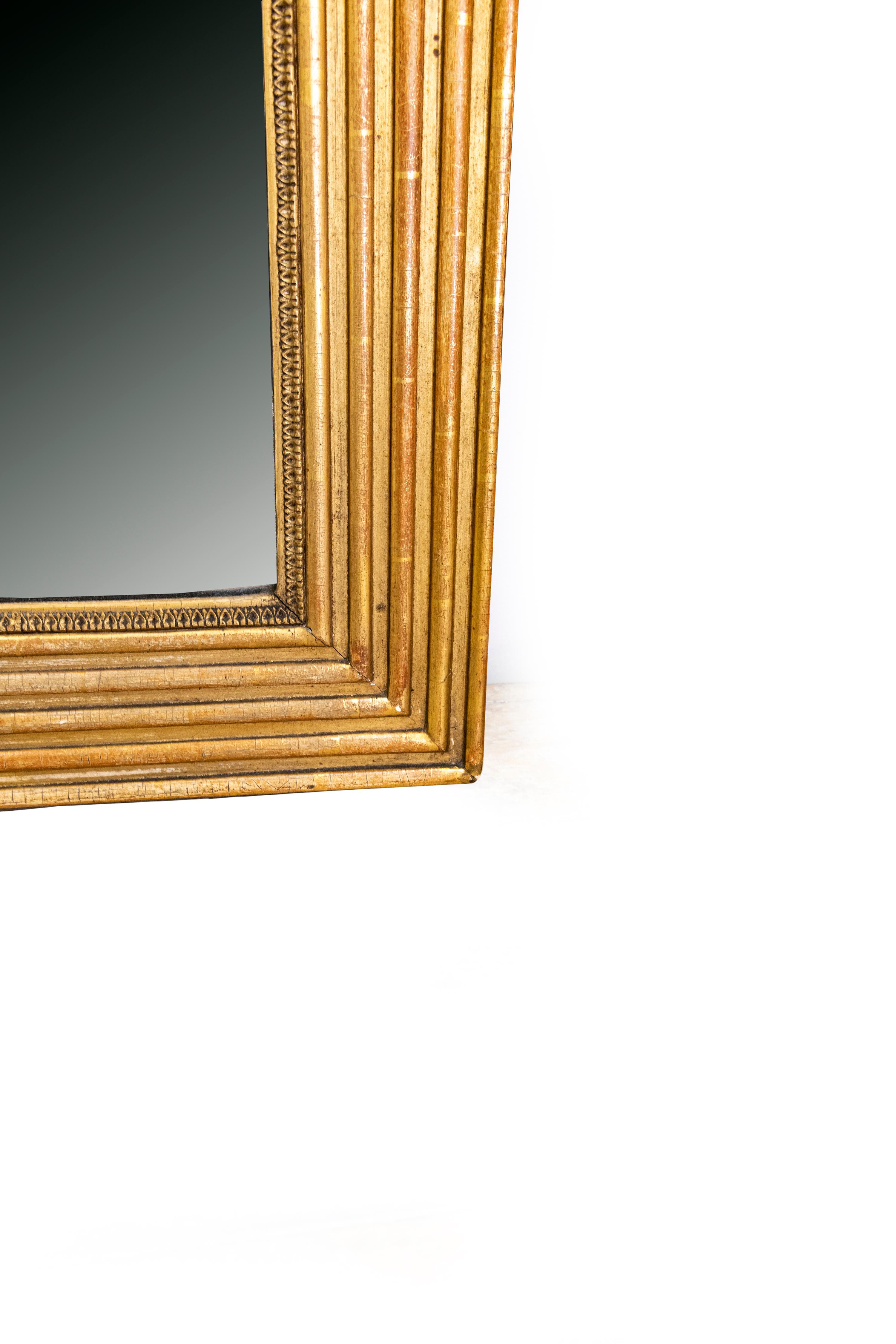 Le cadre est en bon état et les détails de la feuille d'acanthe sur le cadre intérieur sont très particuliers. La dorure est réalisée sur de la bole de Sienne. Le miroir lui-même est nuageux.