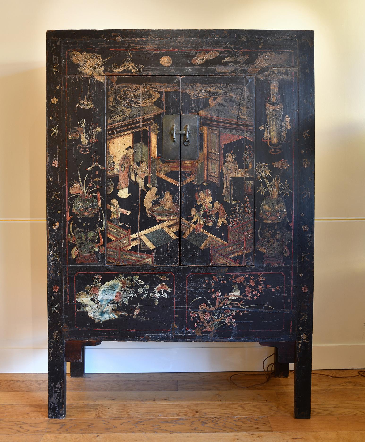 A large black lacquer cabinet, with gold and polychrome motifs depicting birds, flowers, foliage, vases, architecture and scenes of life
The door two doors adorned with a bronze lock, opening to reveal a central shelf, and a secret compartment at