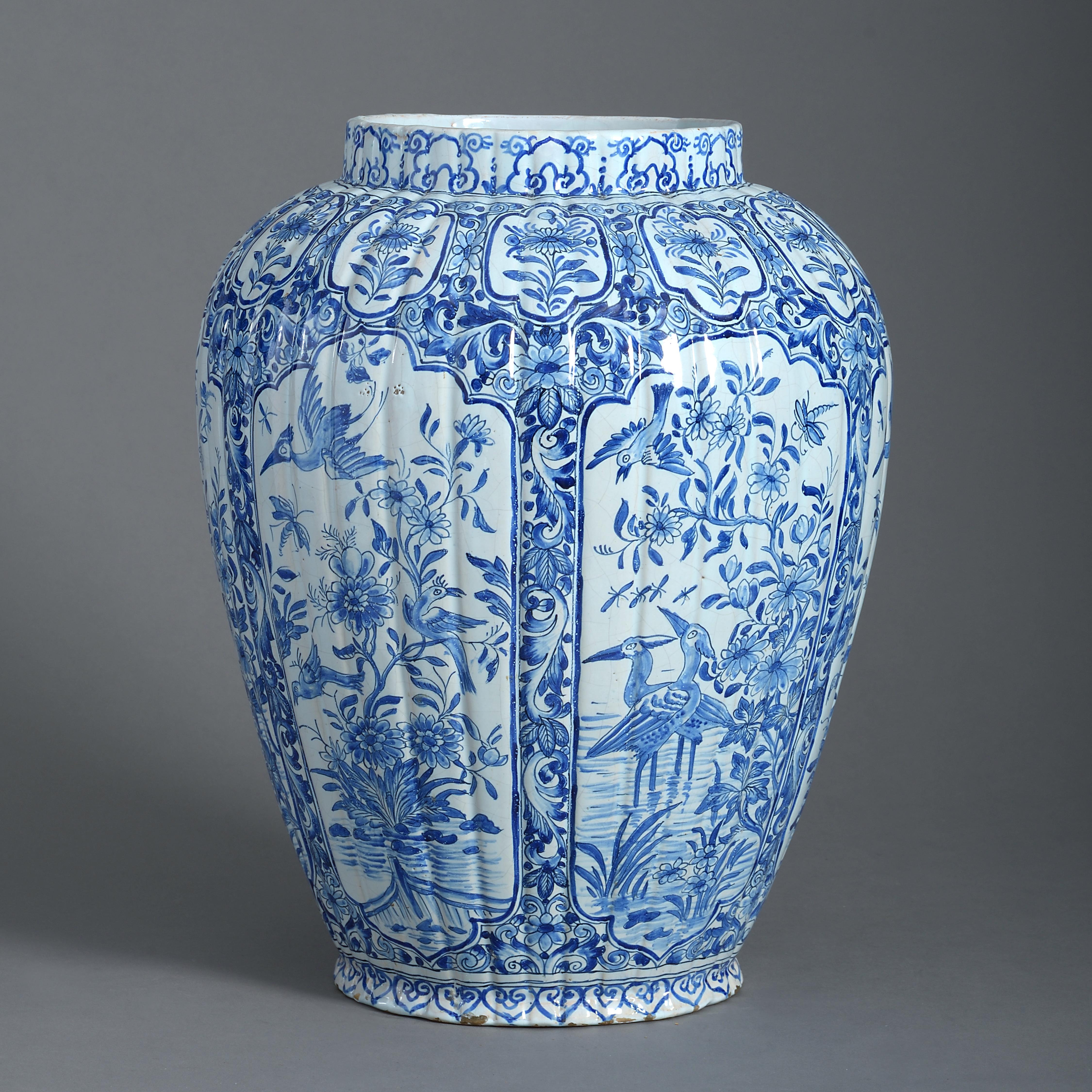 Un vase en poterie de Delft bleu et blanc du début du 18e siècle:: le corps de forme côtelée:: décoré à la manière des Kangxi chinois.