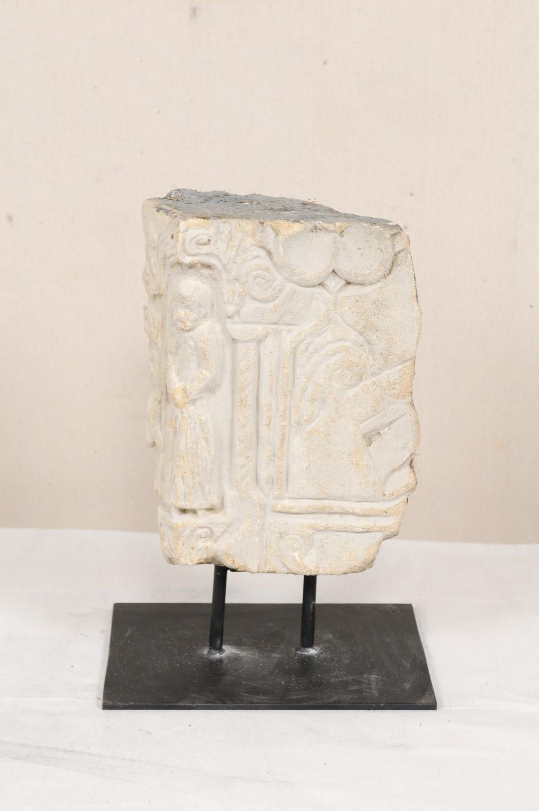 A splendid 18th to 19th century carved stone architectural fragment from Aragon, Spain. This antique architectural fragment from Aragon has been hand-carved of stone, featuring a robed figure standing within a columned entry and decorative