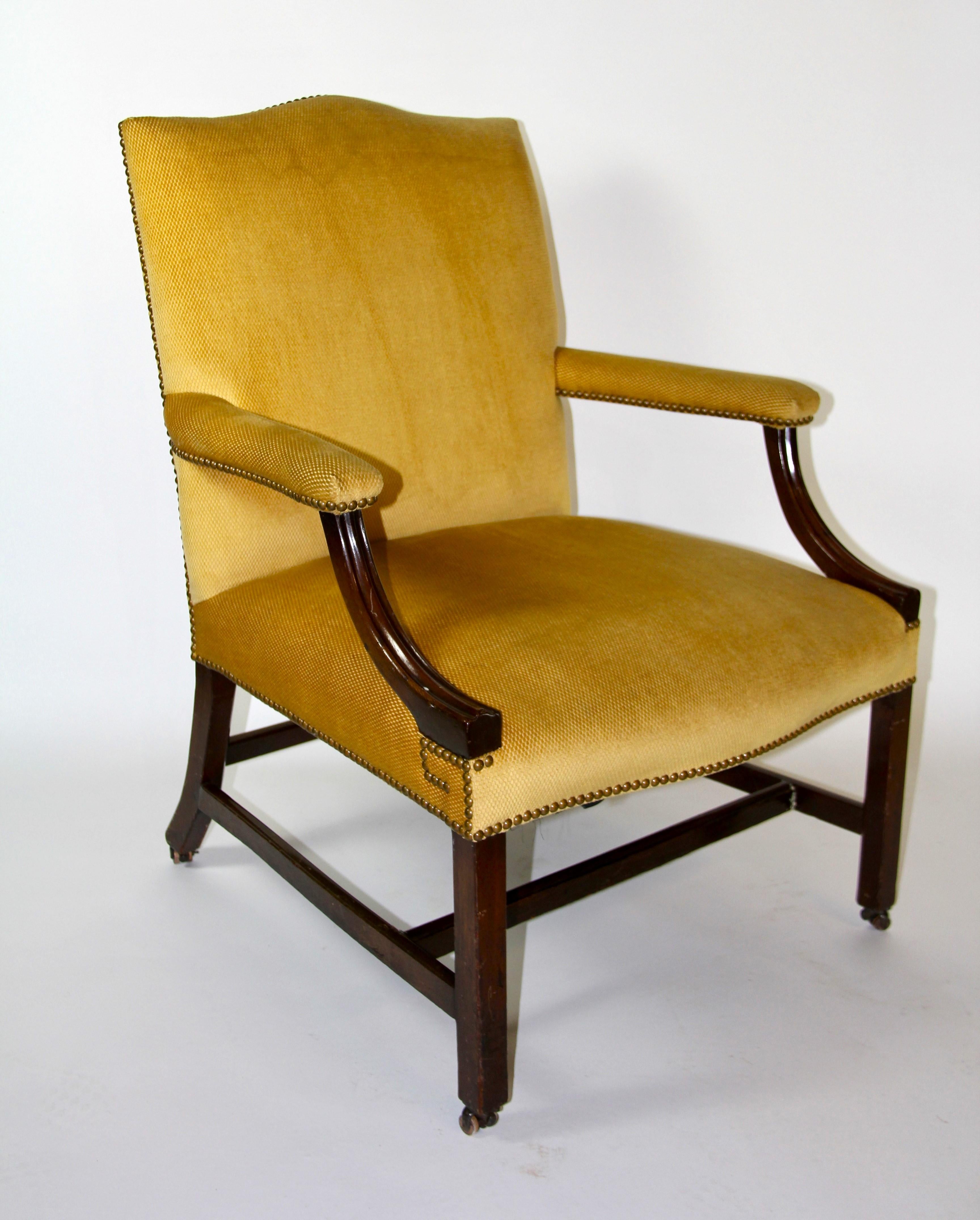 Fauteuil ouvert en acajou sculpté à la main par George III, Angleterre, XVIIIe siècle.  Le dossier rectangulaire, doté d'une traverse subtilement incurvée, est entièrement rembourré et se prolonge par des accoudoirs rembourrés fixés par des supports