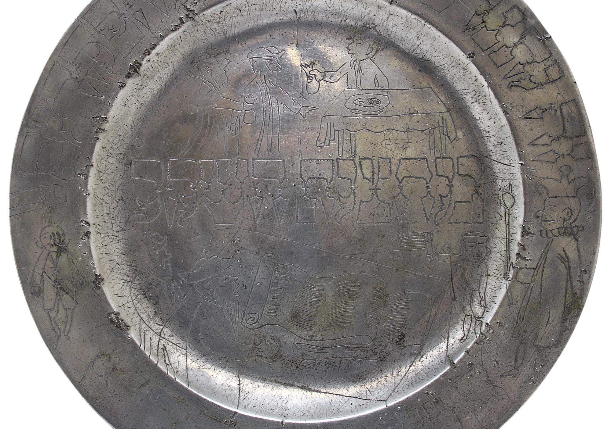 This 18th-century pewter Purim plate is a rare and historically significant item associated with Jewish traditions. It features decorative engravings likely used for collecting alms, especially during Purim, a Jewish holiday that emphasizes charity