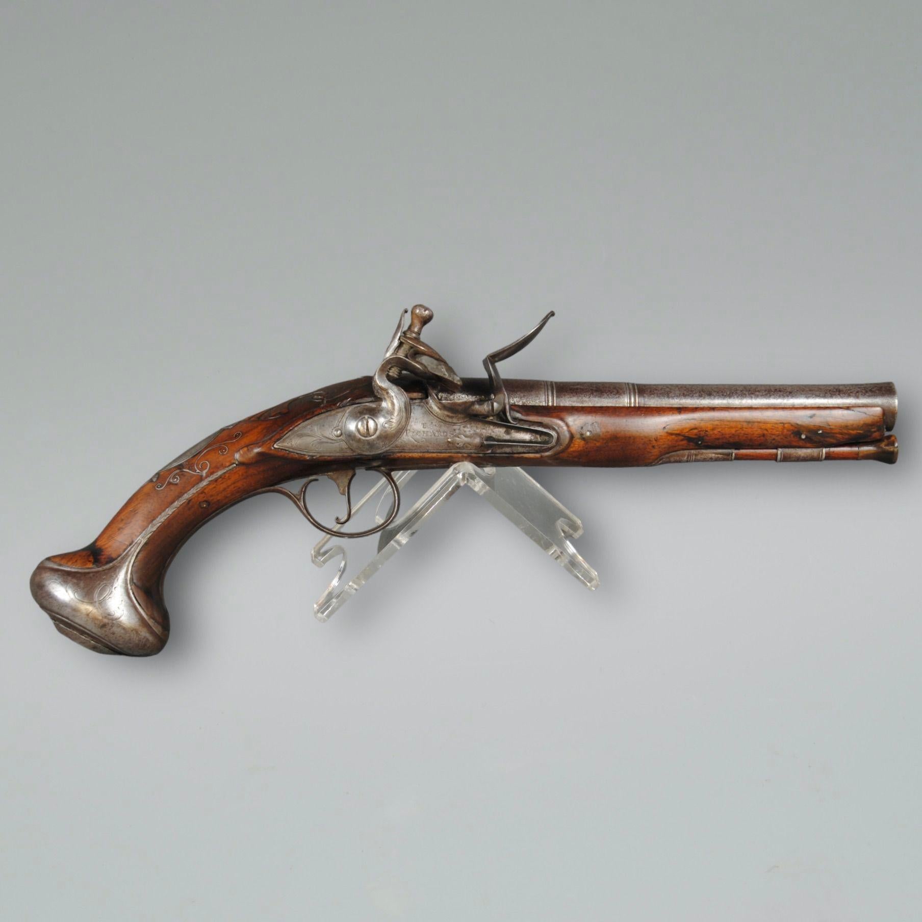 An 18th century flintlock holster pistol with carved and inlaid walnut stock and a two staged, proof marked barrel. 
The lock signed T Richards.
Barrel length 19cm