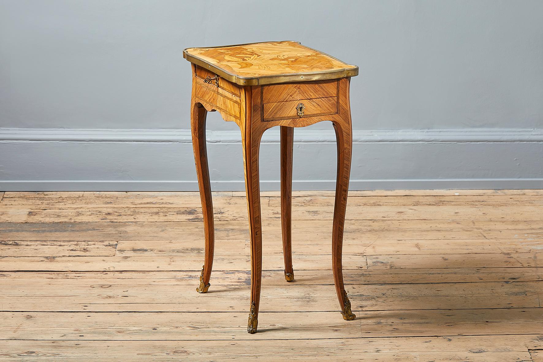 A fine French ormolu-mounted tulipwood, kingwood and Marquetry table an ecrire, circa 1850, the top inlaid with tulips and poppies within a cartouche, above a frieze drawer and two side drawers, on cabriole legs and sabots.