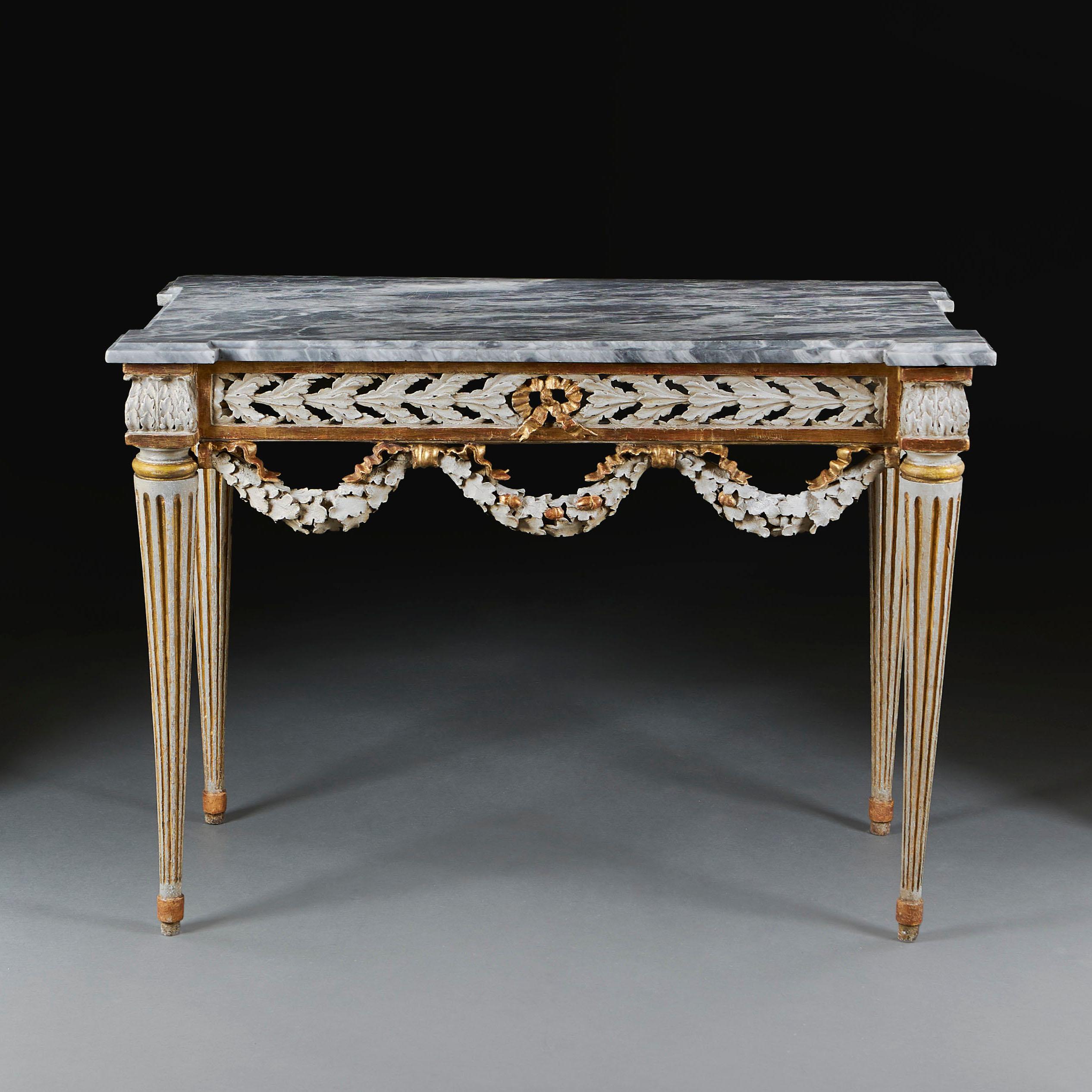 A late 18th century painted French console table, with fluted legs, the pierced foliate frieze with garlands of oakleaves and acorns. Parcel gilded, retaining the original grey Fior di Bosco marble top with canted corners. 
France, circa