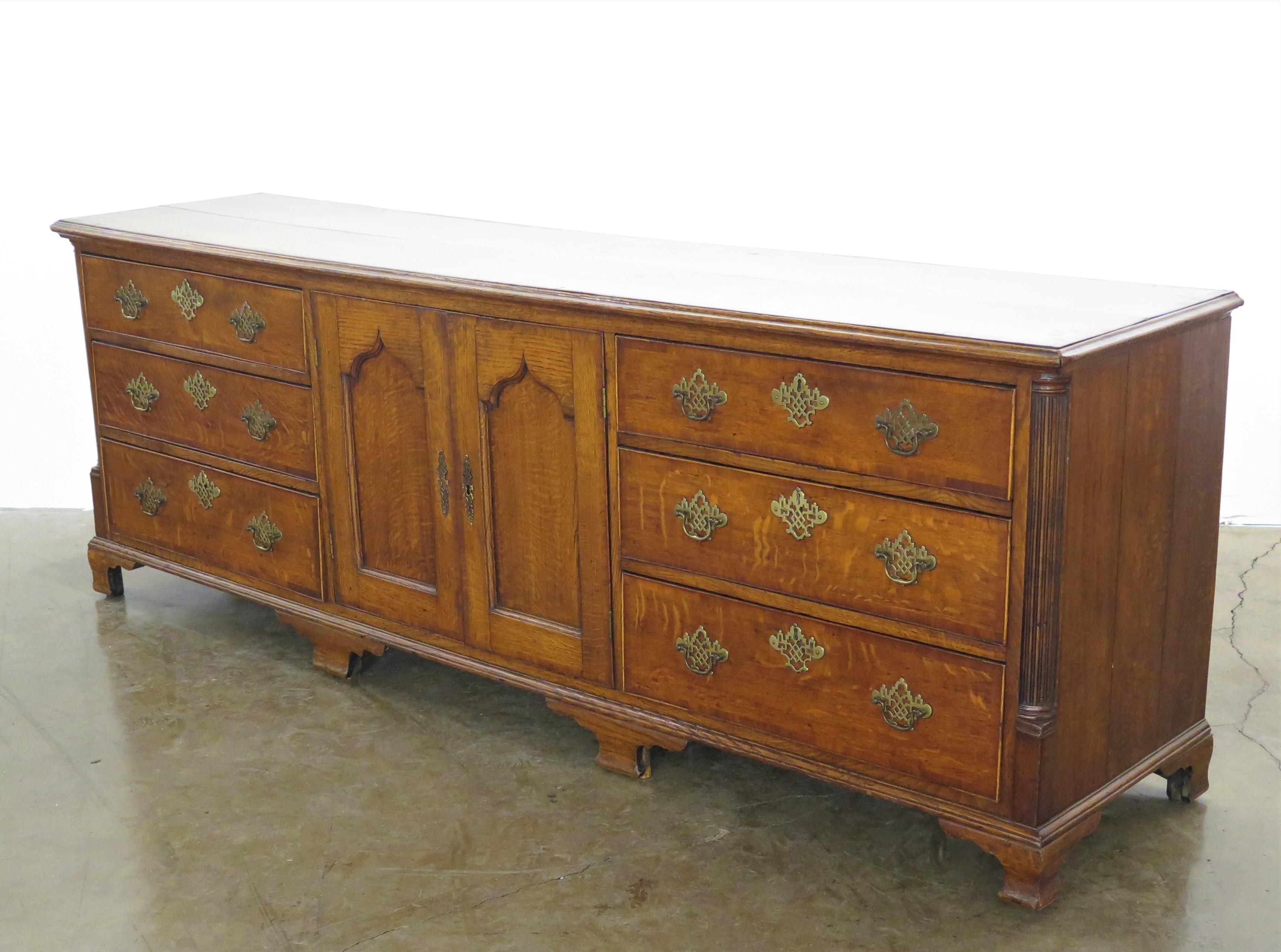 An 18th Century Georgian oak dresser base, moulded rectangular top, this dresser base has superb color and proportion, there are six drawers and a pair of panelled doors. English. 