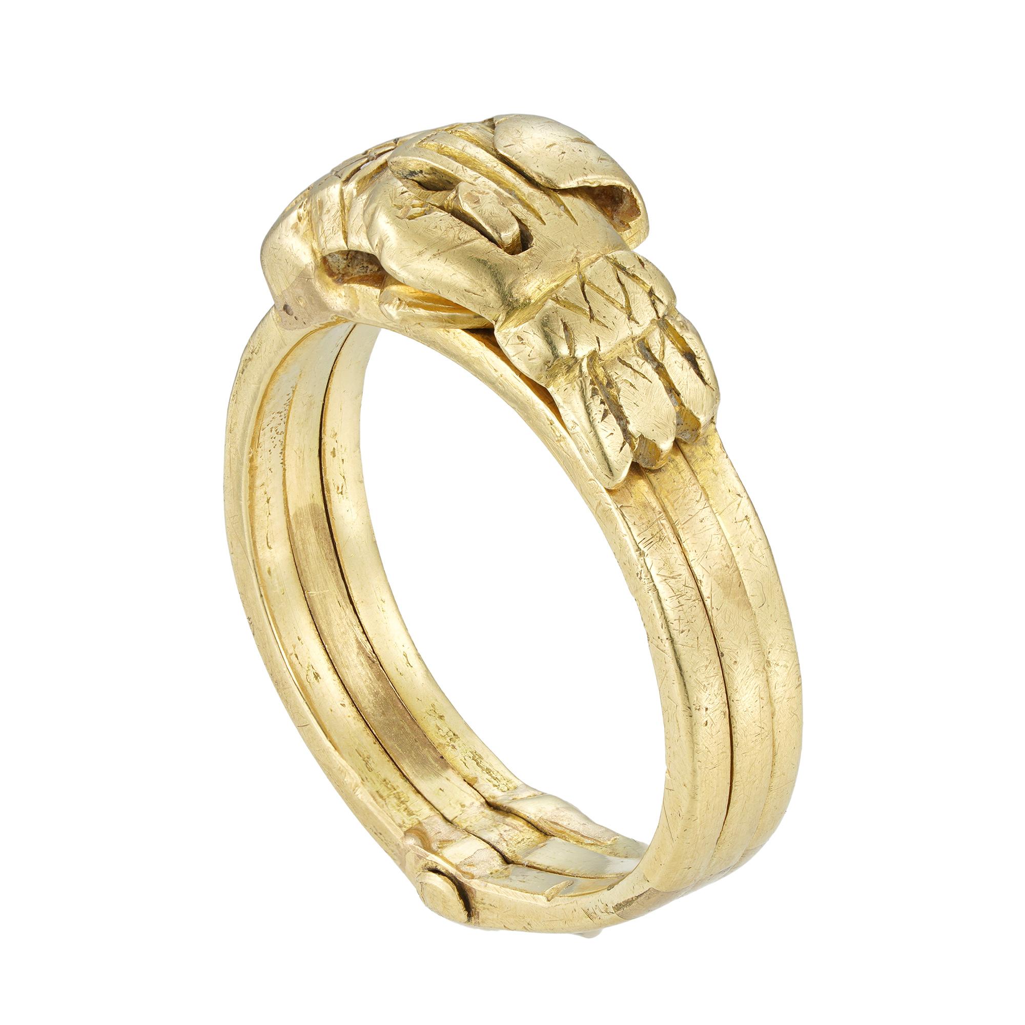 Ein goldener Gimmelring aus dem 18. Jahrhundert, bestehend aus drei separaten Ringen, die so miteinander verbunden sind, dass sie unbemerkt als ein Ring zusammenpassen, verziert mit zwei ineinandergreifenden Händen, die auseinandergezogen werden, um