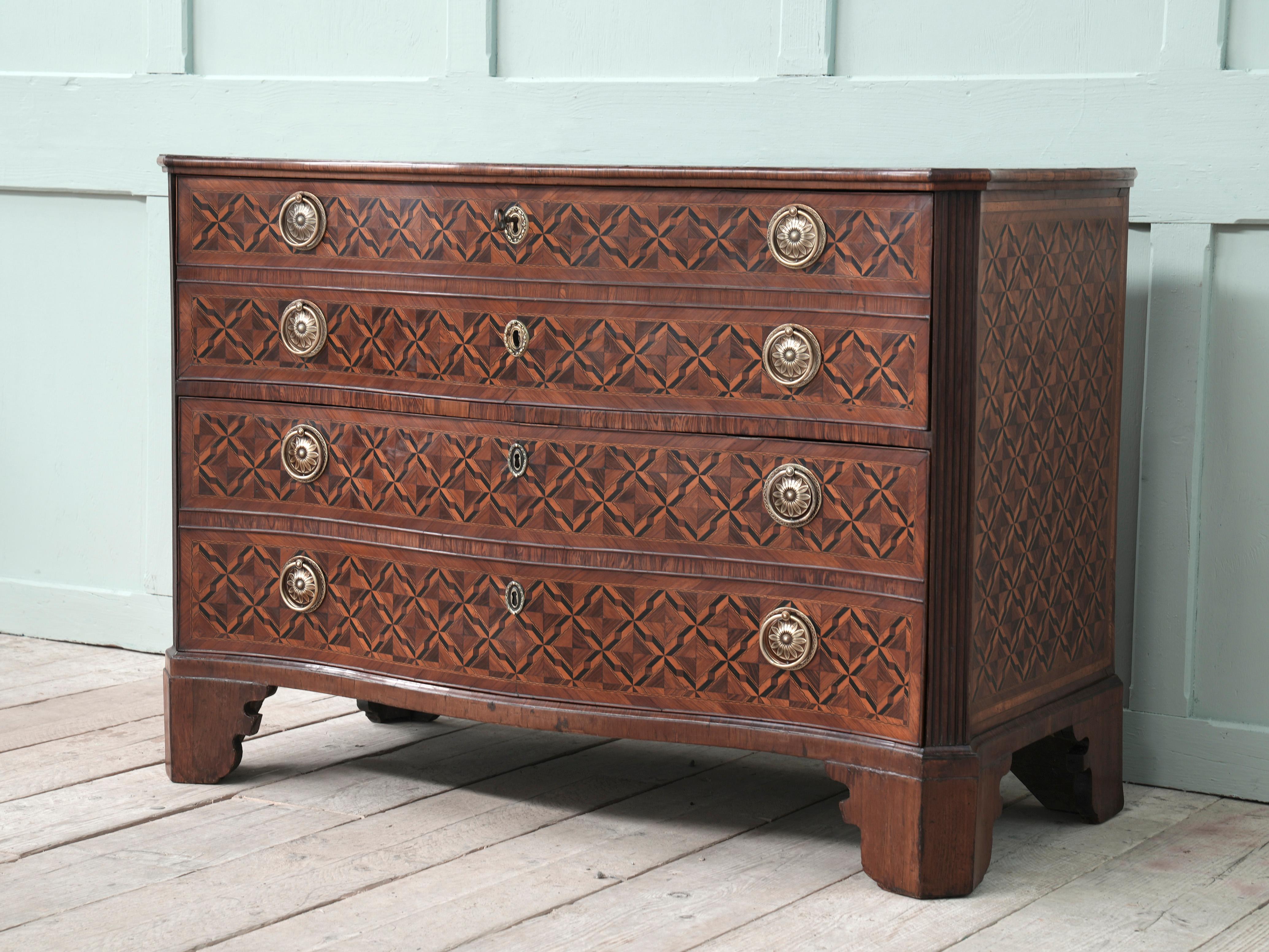 A fine late 18th century Italian marquetry veneered serpentine two drawer commode chest of drawers.

The shaped bracket feet below canted and reeded corners flanking the serpentine drawers, geometric inlay in multiple exotic fruit and hardwoods,