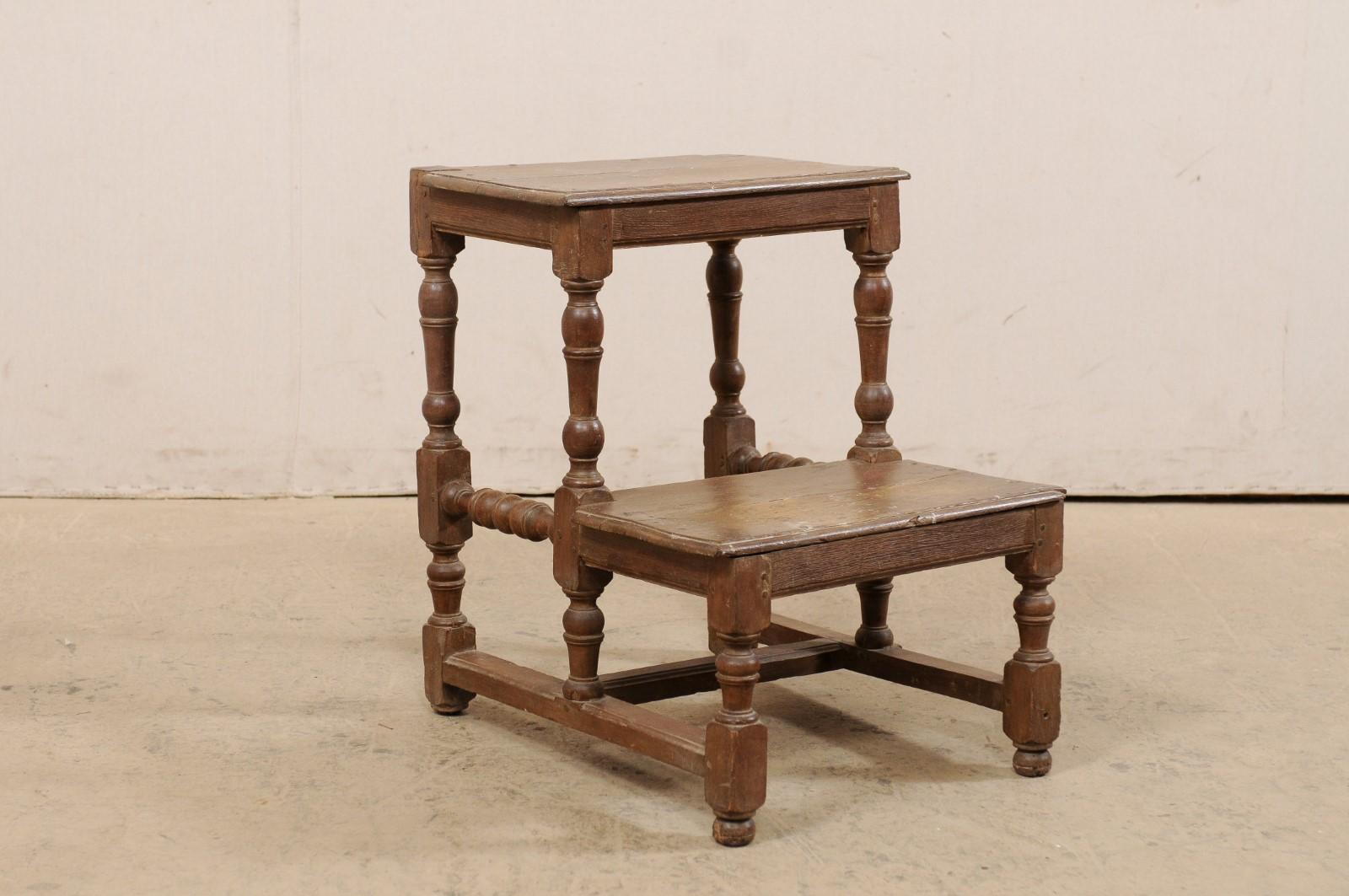 An Italian walnut step stool from the 18th century. This antique two-step stool from Italy has a decorative walnut spool turned structure. The steps are in good condition and have a rich, aged patina throughout. This 18th century Italian step stool
