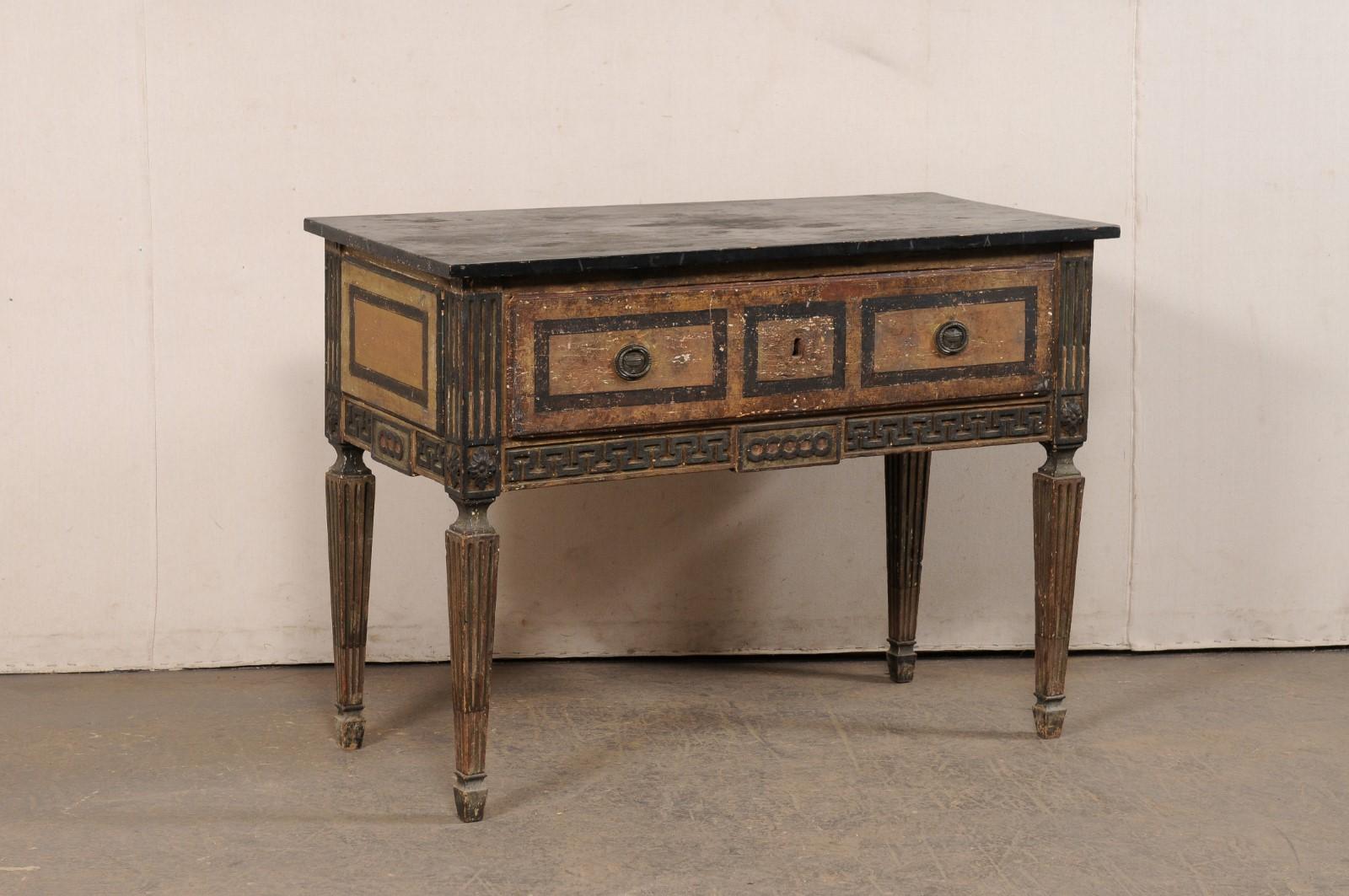 Consola italiana de madera tallada, que conserva su acabado pintado original, del siglo XVIII. Esta mesa antigua procedente de Italia tiene un tablero de forma rectangular y pintado de imitación al mármol, que sobresale ligeramente por encima del