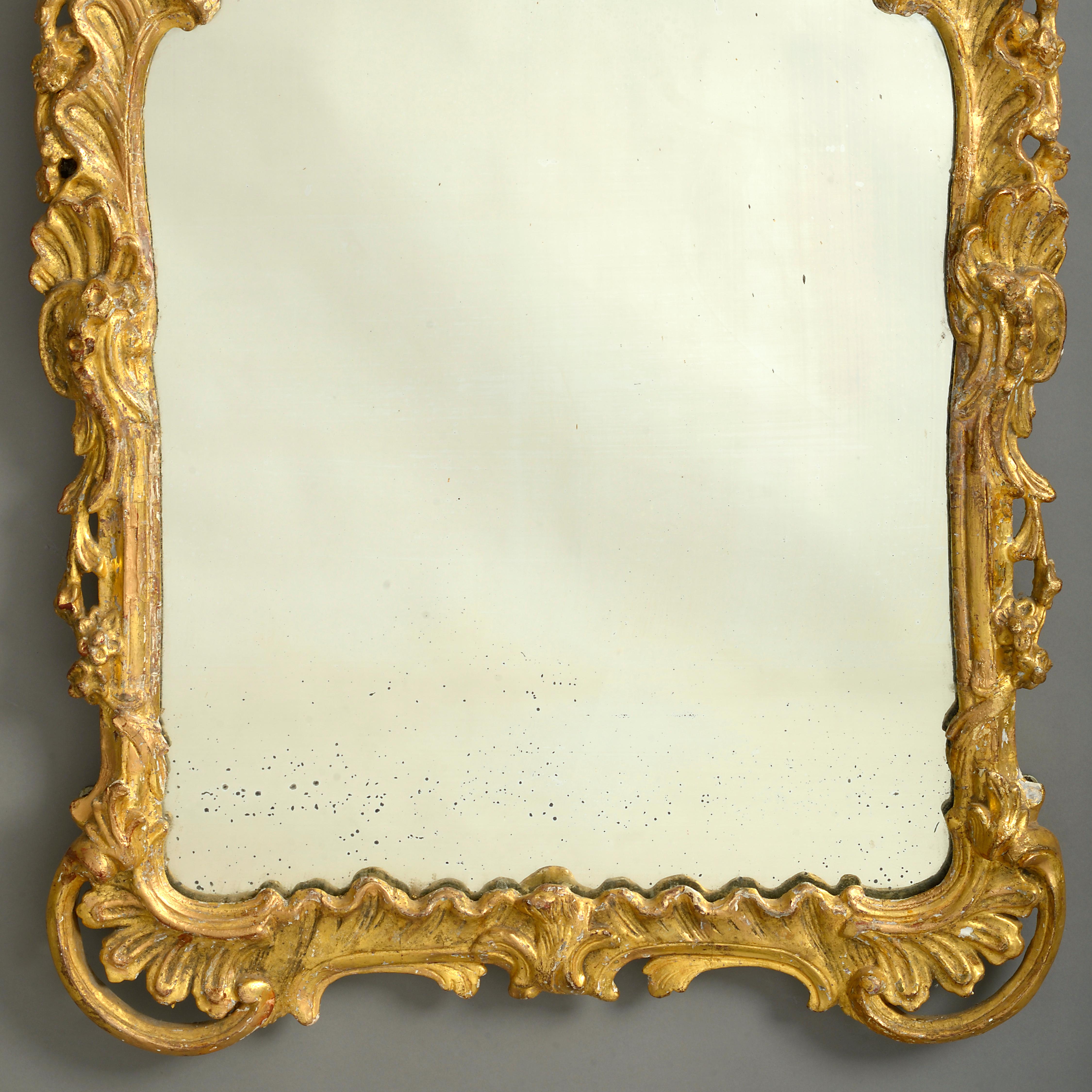 A mid-18th century Louis XV period giltwood mirror in the Rococo taste, the carved giltwood frame with floral, rocaille and foliate decoration throughout.