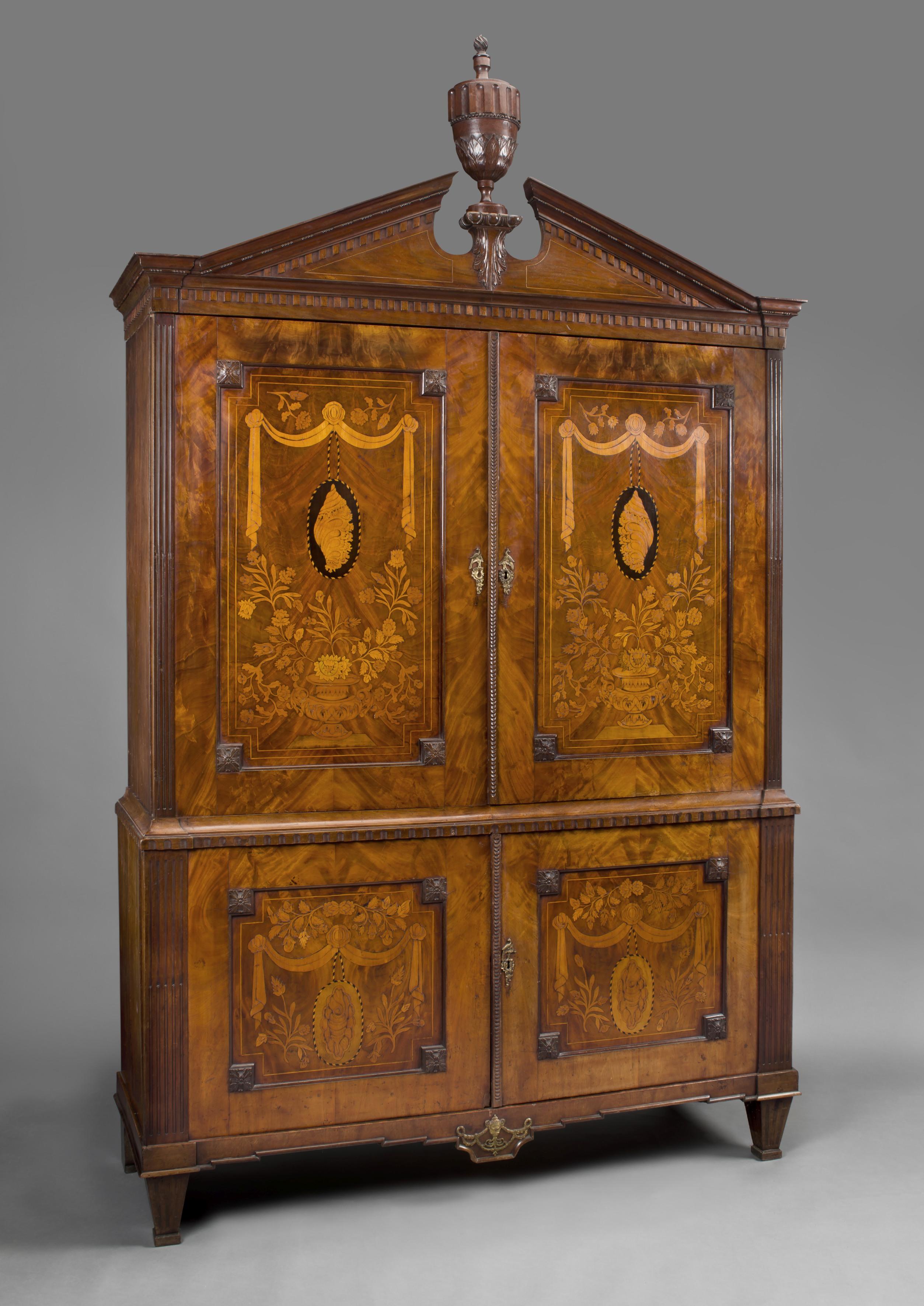 An 18th century Dutch neoclassical mahogany armoire with floral marquetry inlay.

Dutch, circa 1770. The marquetry inlay circa 1860. 

The impressive and very decorative armoire has a moulded broken pediment with a central urn, above panelled