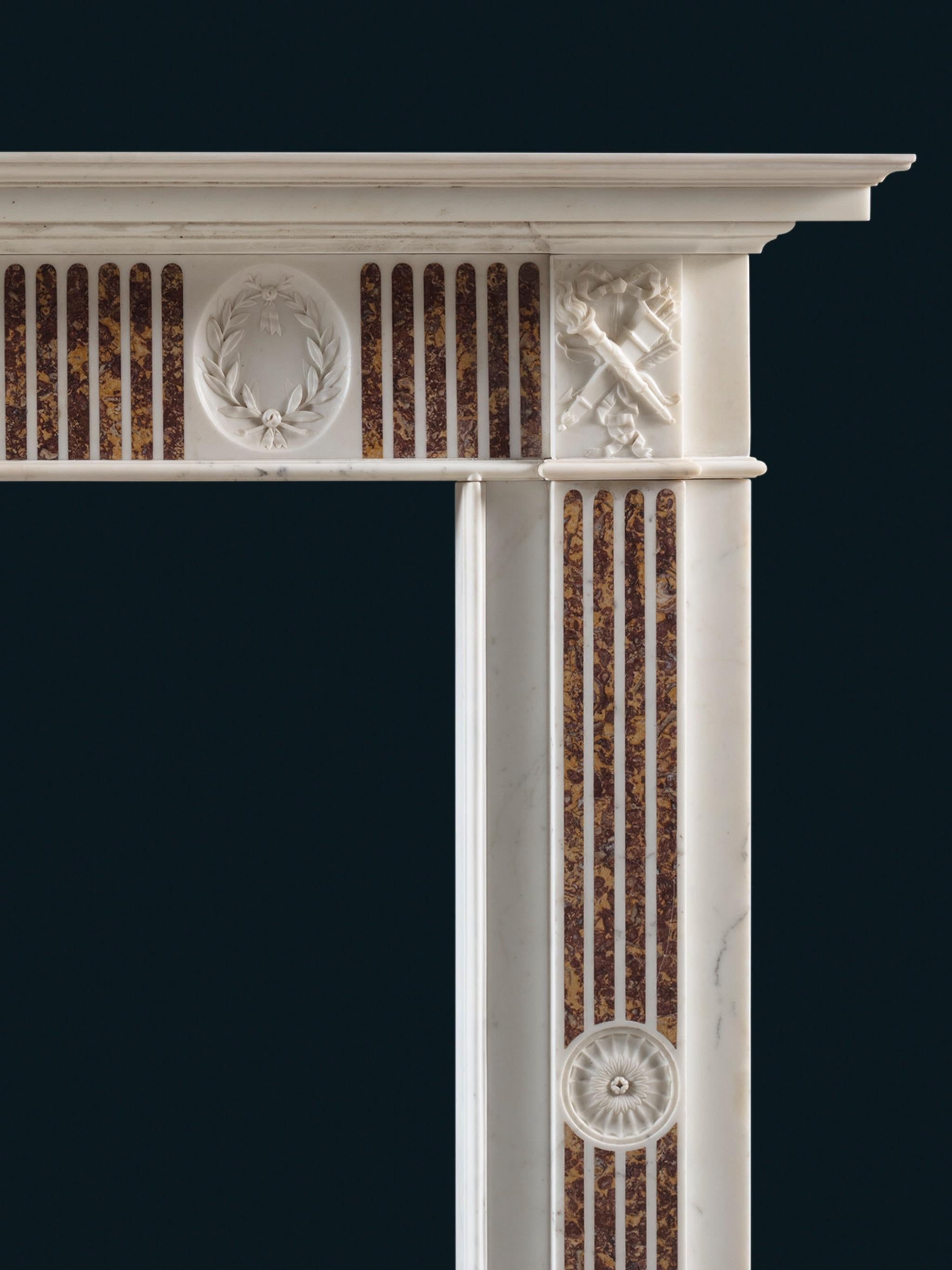 Un camino del XVIII secolo eccezionalmente finemente intagliato, di design neoclassico, in marmo bianco statuario con intarsi in broccatello spagnolo

Dalla collezione di Will Fisher presso Jamb, Londra 

Il ripiano sagomato è sostenuto da un blocco