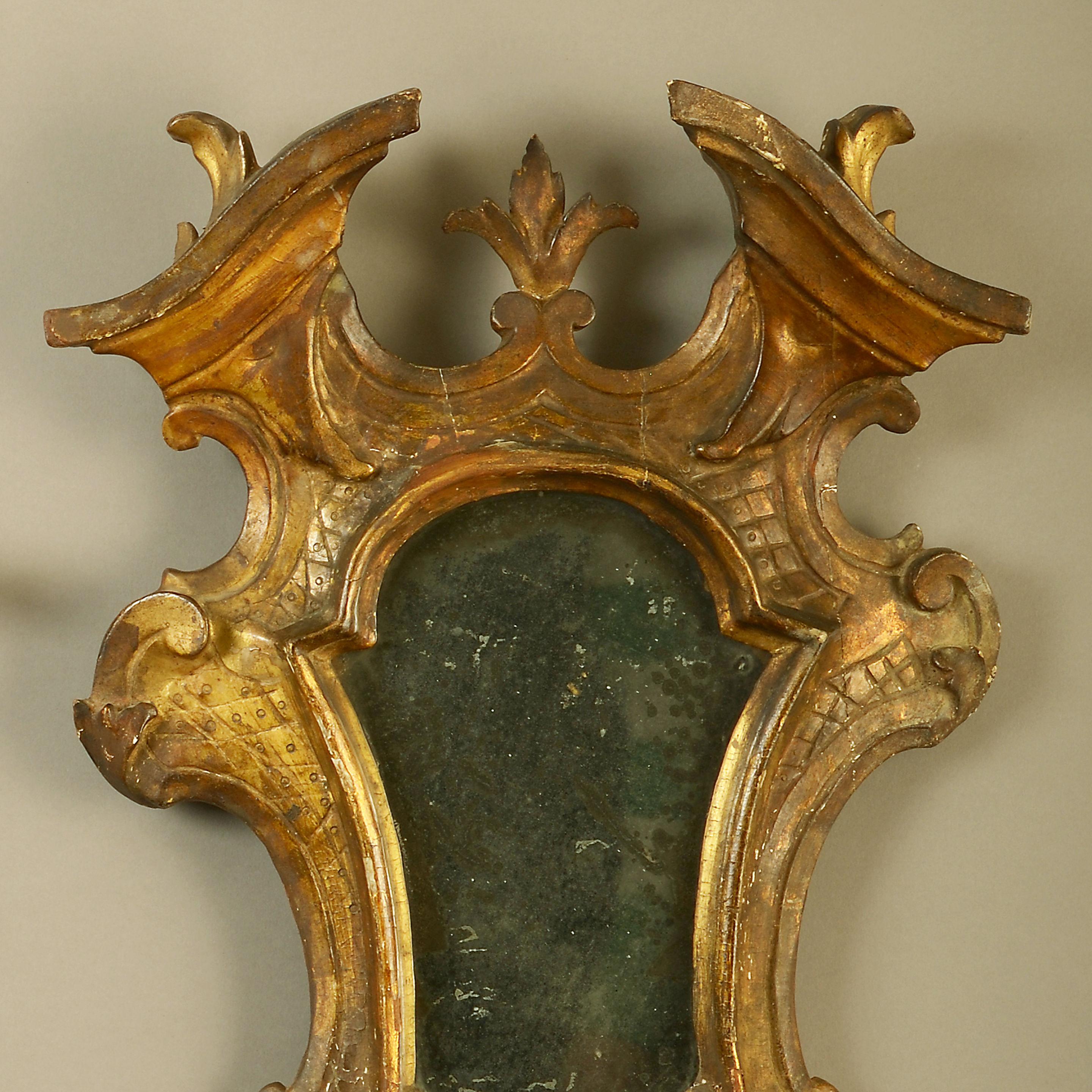 A fine mid-18th century Venetian pair of carved giltwood girandole mirrors in the Rococo taste. Retaining the original mercury plates.