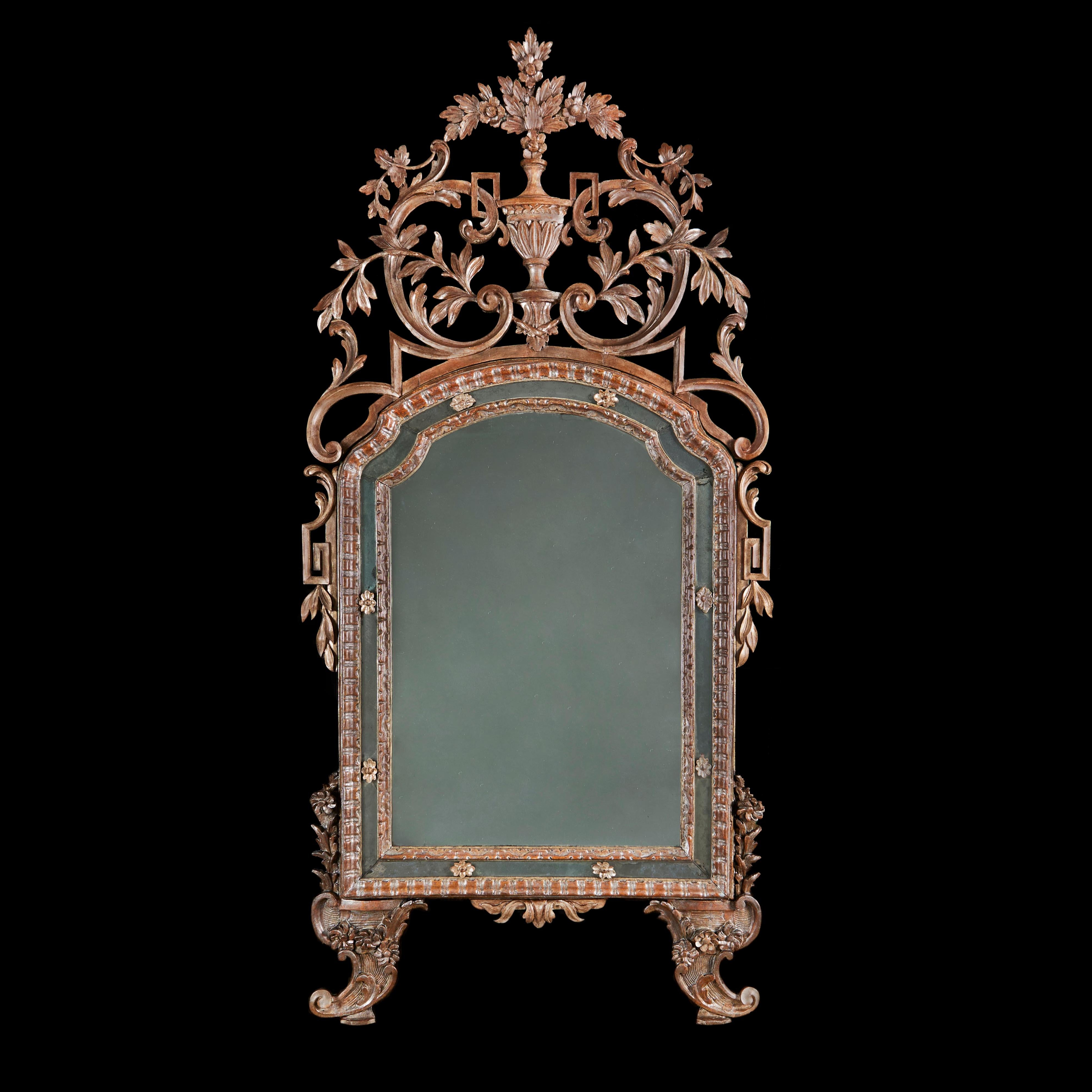Piedmont, Italy, circa 1780

An exceptional late eighteenth century Rococo pier mirror, with carved and pierced cresting of foliate design with a central urn and spray of flowers, the frame also with Greek Key elements to the sides and scrolling