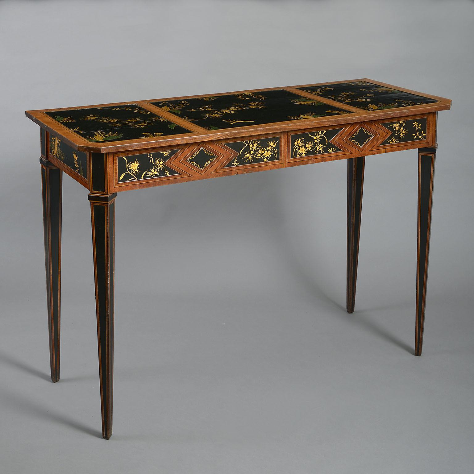 The canted top inset with three fine gilt-decorated lacquer panels between cross-banded borders, above a frieze with further lacquer panels, raised on angled square tapering legs.
 