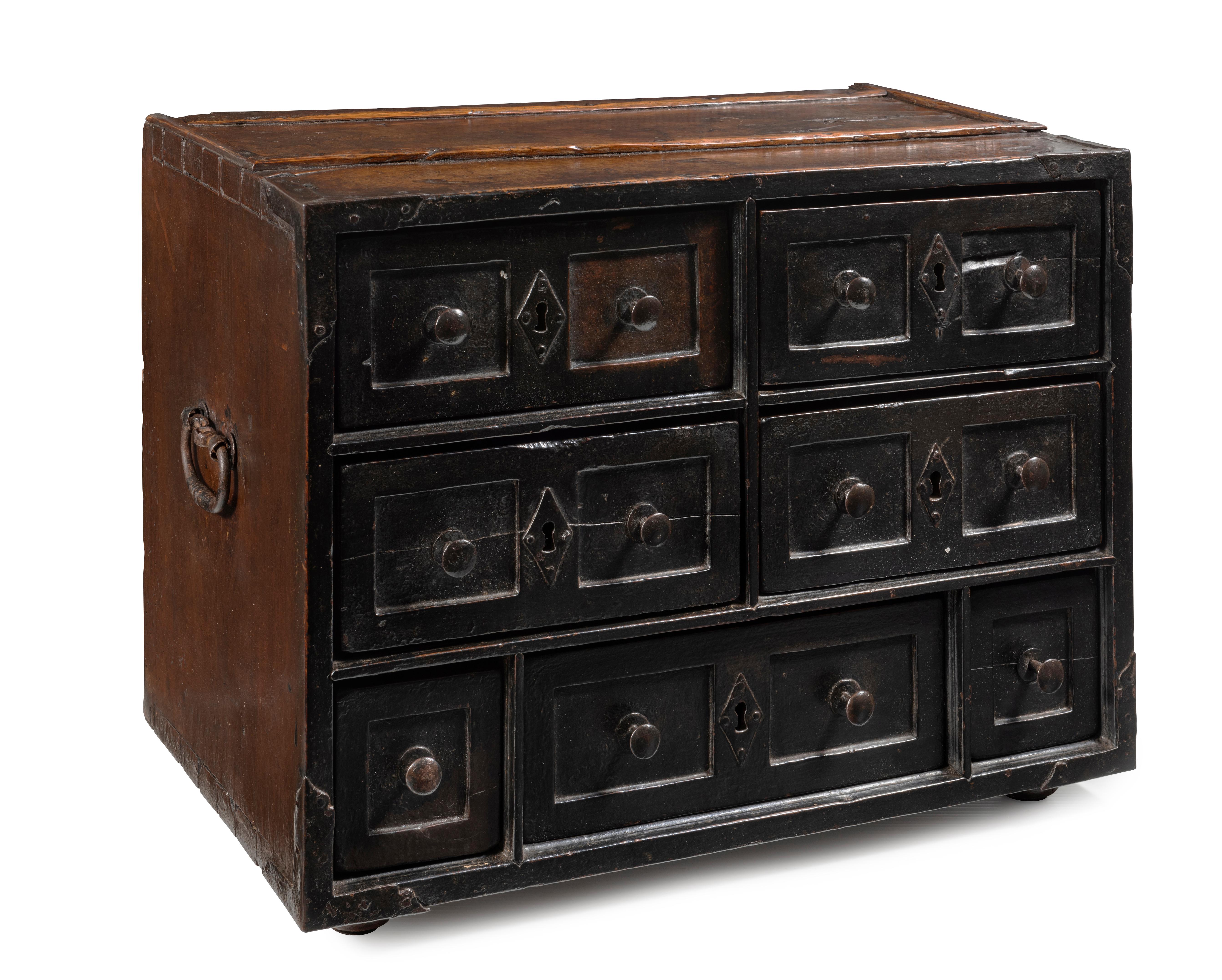 The plank top over three rows of seven drawers, the top and middle comprised of four conforming rectangular panels, each with central bronze diamond shaped escutcheon flanked by a pair of rounded brass handles in recess, the lower bank with
