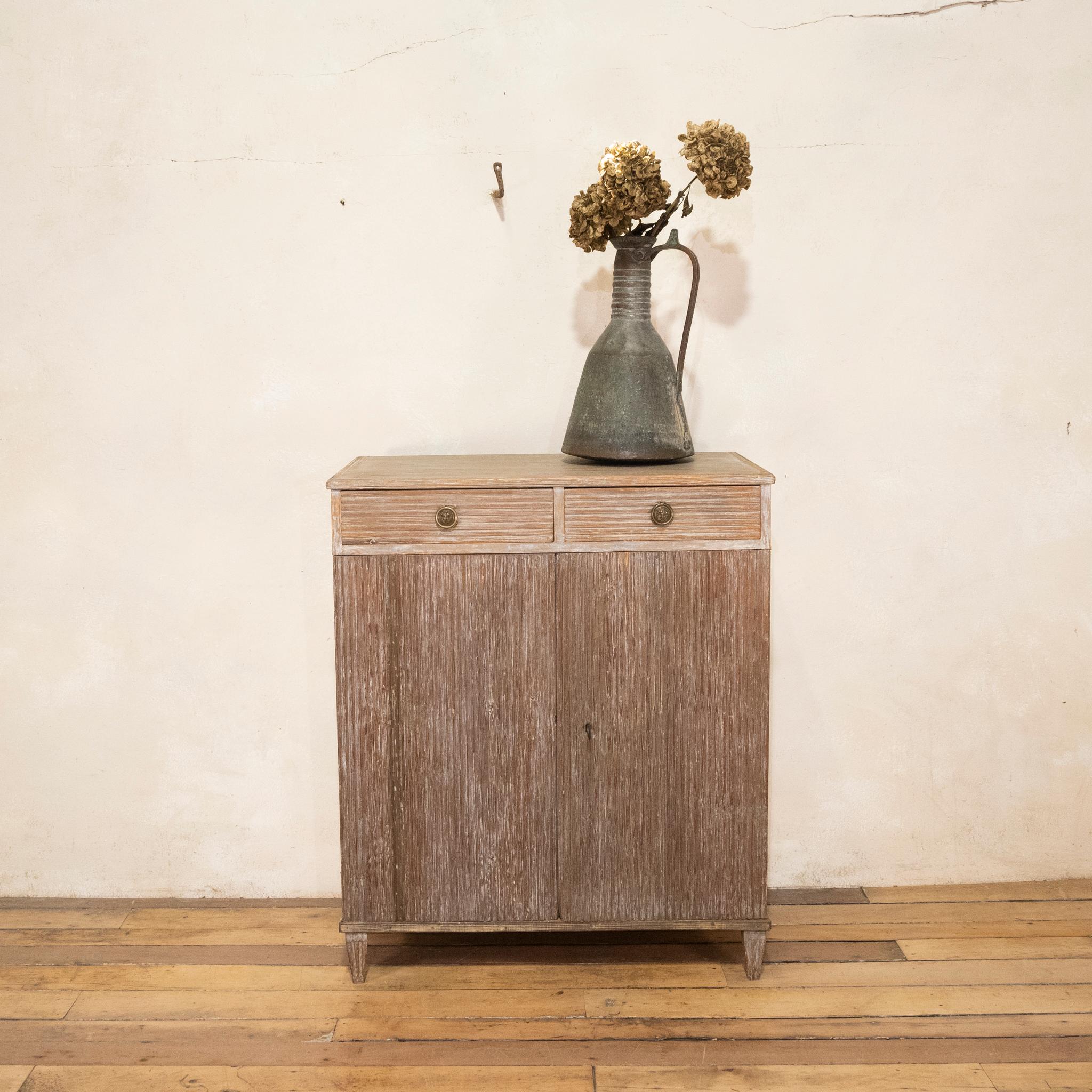 A striking late 18th-century Swedish dry scraped sideboard cabinet.
Displaying a wonderful old Patina presenting a mixture of colours displaying tones of white & natural wood. Displaying a pair of drawers above a pair of carved reeded decorations