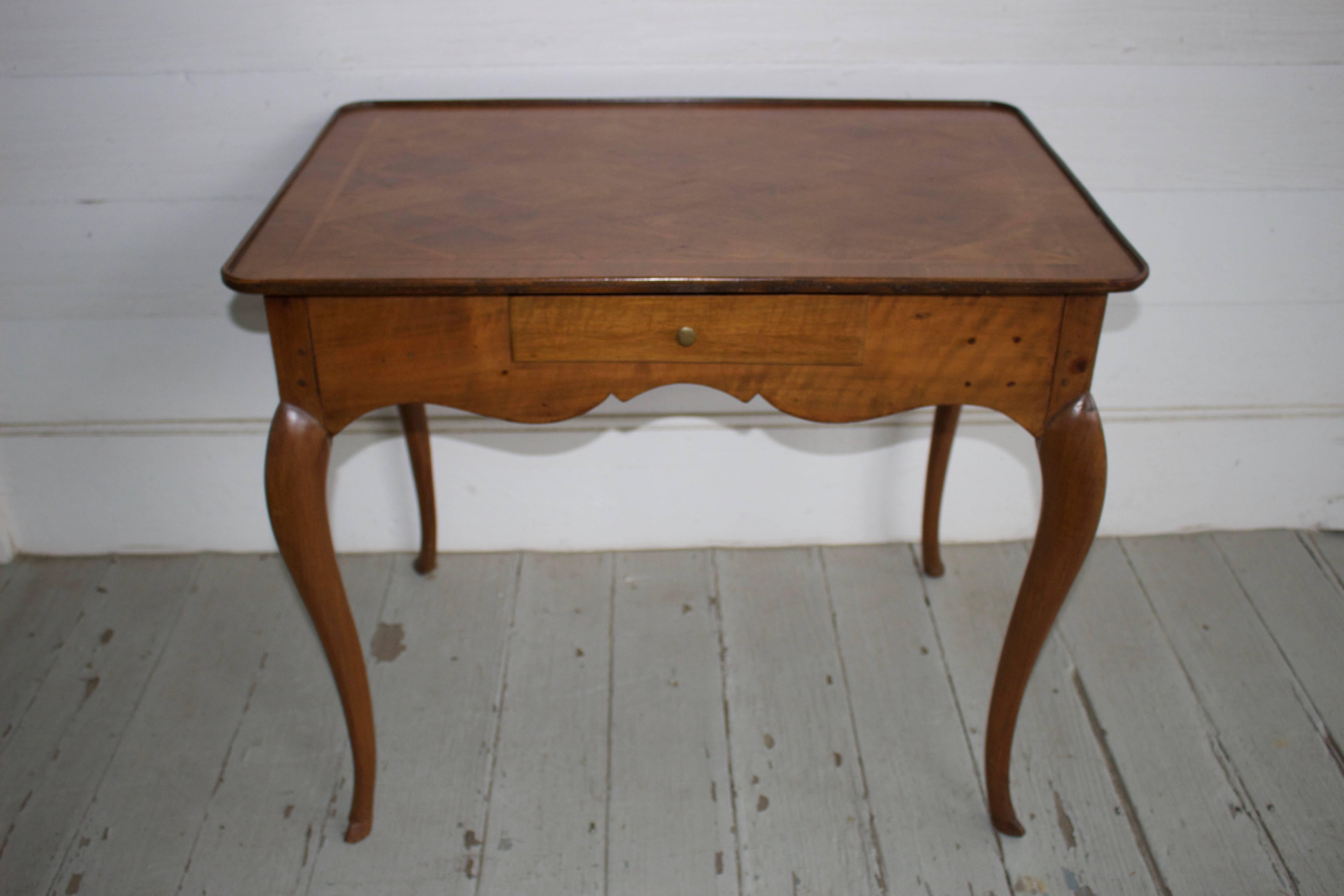 A beautiful Swiss walnut writing table with a burled parquetry top from the Neauchatel region of Switzerland. These tables are ideal to use next to a sofa, bedside or has a tea or cocktail table in front of a sofa.