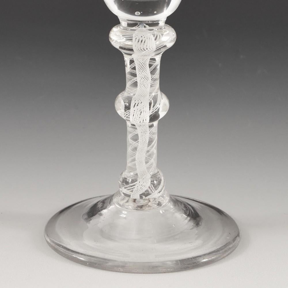 Heading : An 18th Century Triple Knop Opaque Twist Glass
Period : George II - George III
Origin : England
Colour : Clear- light grey-blue tone
Bowl : Bell shaped with thickened base
Stem : Graduated annular knop, flattened ball knop and ball