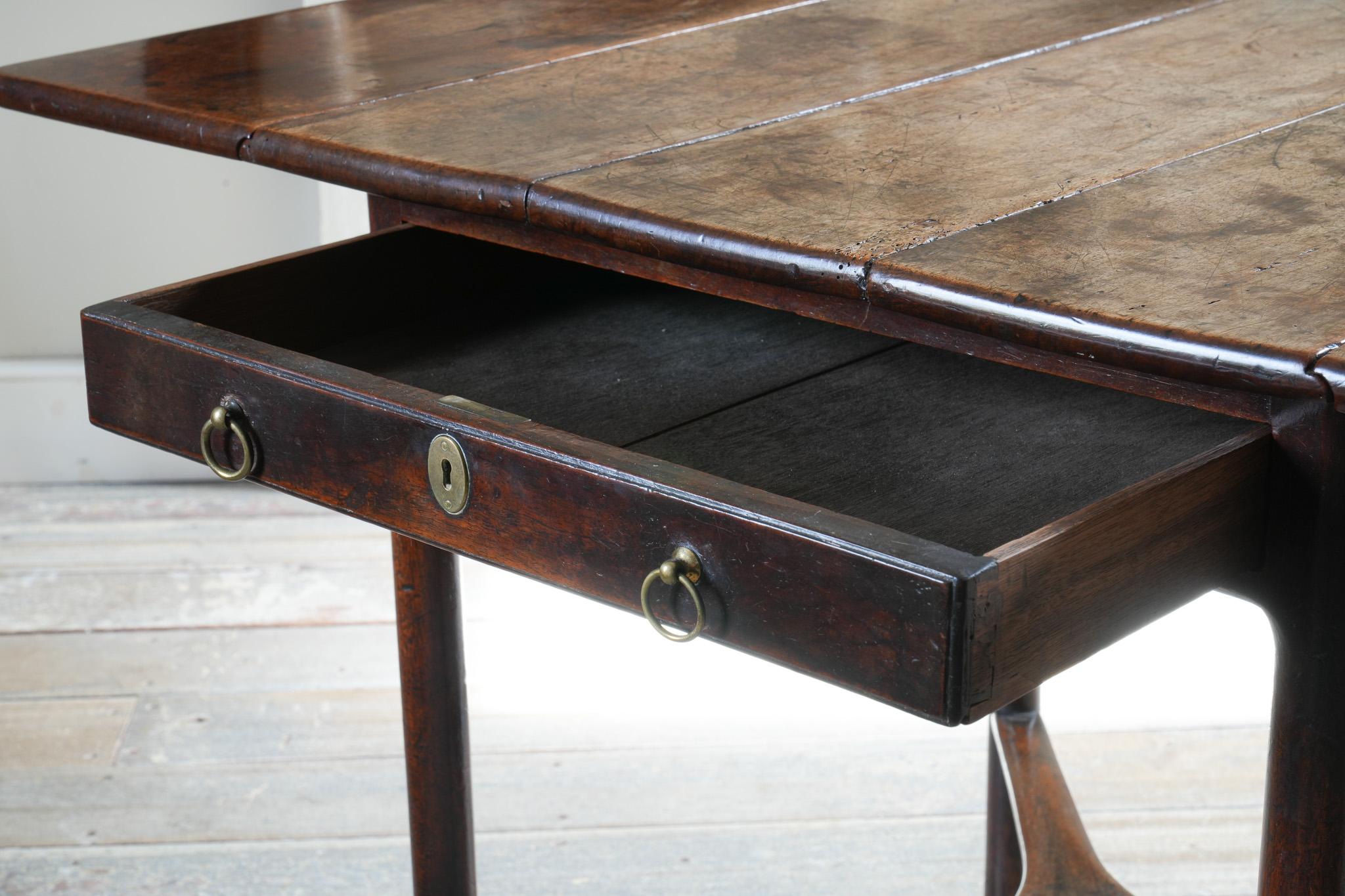 The rectangular twin-flap top above a single frieze drawer with original brasses, round molded legs, with original brass castors.

A superb and completely untouched example with numerous unusual stylistic nuances.

(Extending width: 103