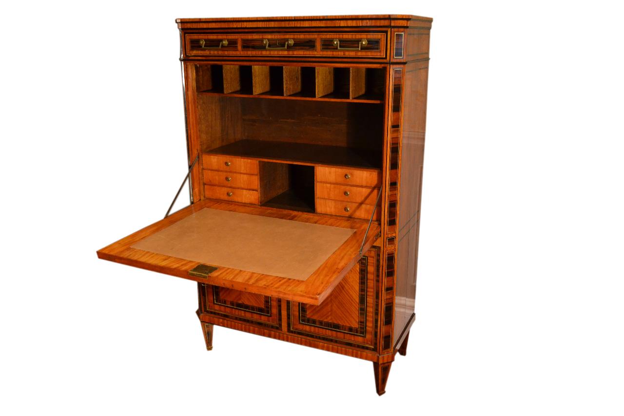 An 18th century Dutch satinwood abbatant or drop front desk, with gilded beading and inlaid brass stringing. The case also has various exotic woods inlaid into the satinwood. There is a drawer in the frieze above a fall-front door enclosing a fitted