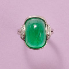 An 1960s Platinum Ring with a Cabochon cut emerald and Diamonds
