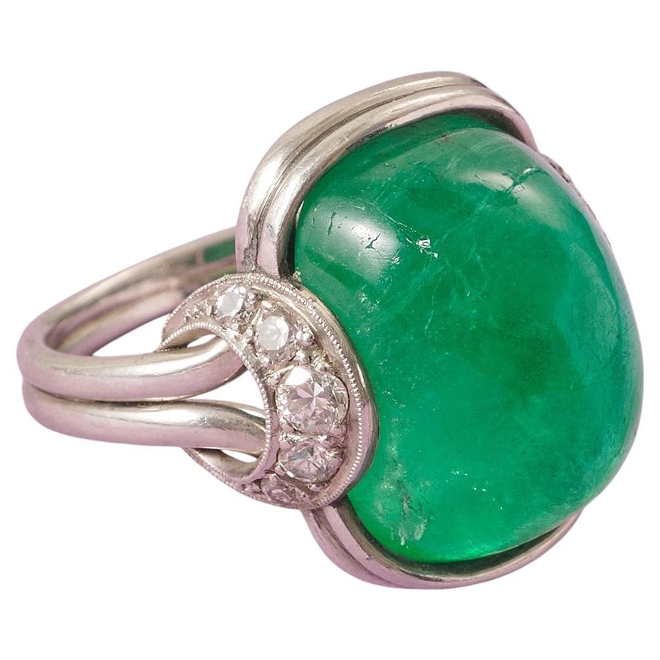 An 1960s Platinum Ring with a Cabochon cut emerald and Diamonds