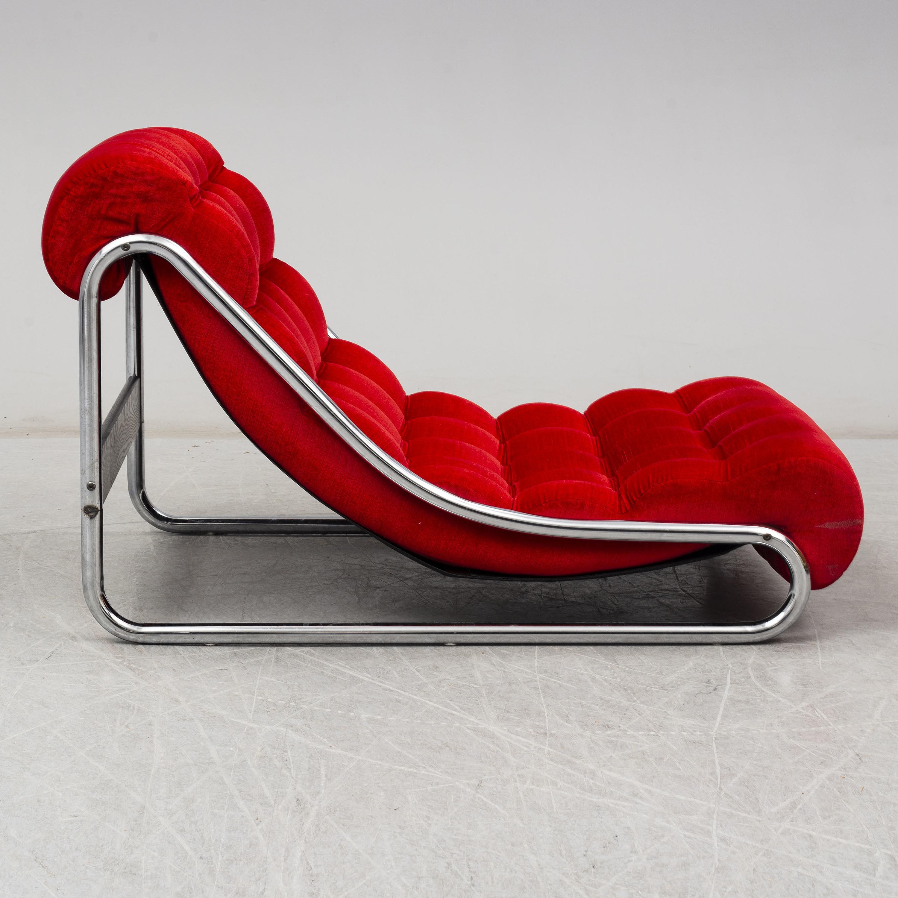 An ‘Impala’ easy chair designed by Gillis Lundgren for IKEA, with tubular steel frame and the curved seat upholstered in a vibrant red fabric.