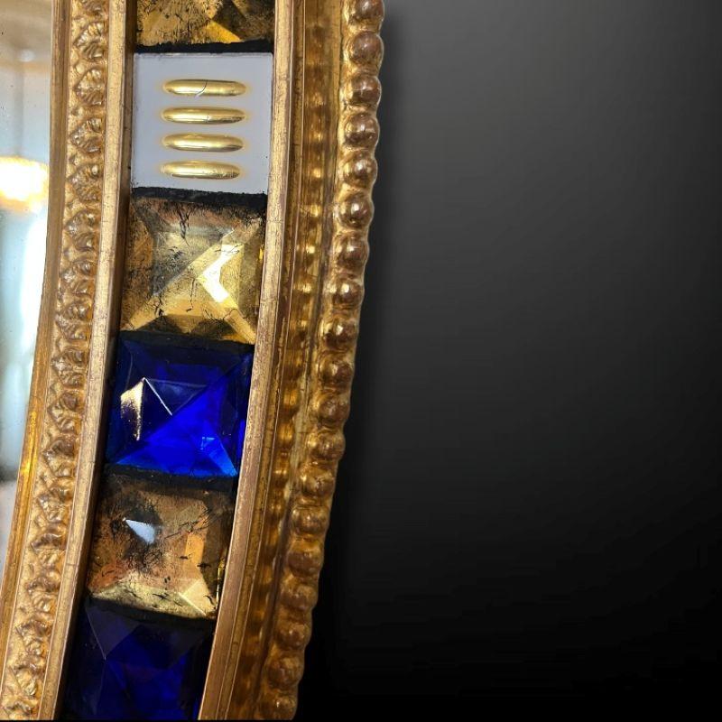 Magnifique miroir ovale du 19e siècle, d'une taille impressionnante, avec une bordure en bois doré et des bijoux à facettes en verre bleu et clair insérés plus tard - la décoration en verre taillé dans le style du cristal de Waterford.  