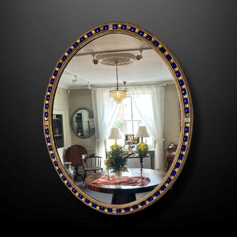 XIXe siècle Un site  Miroir mural ovale en bois doré du 19ème siècle avec des bijoux en verre bleu et doré en vente