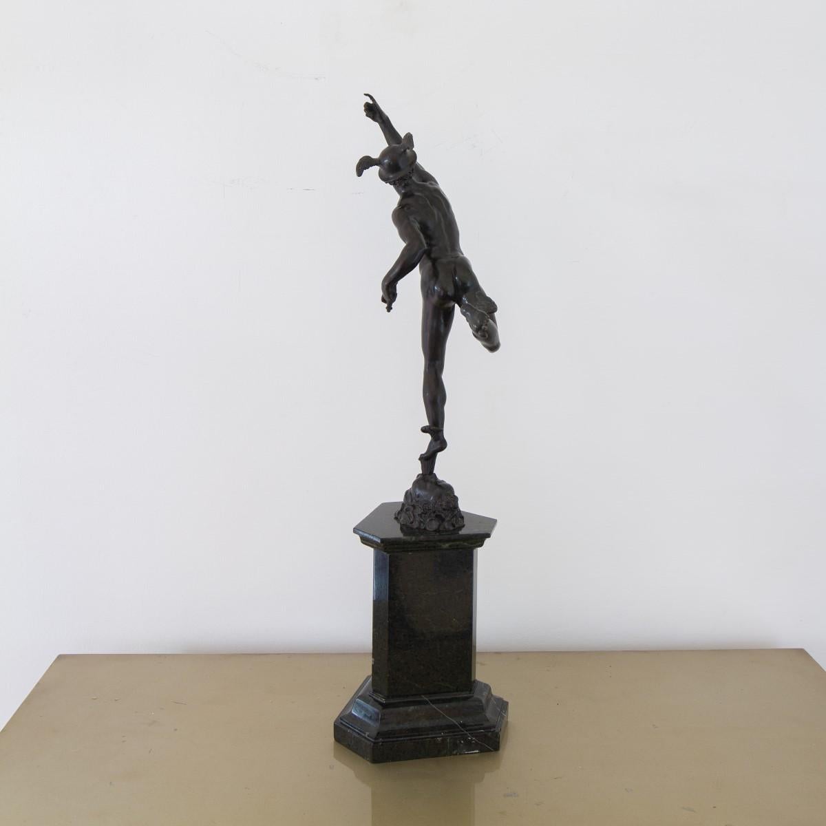 A 19th century grand tour bronze Mercury balancing on a bronze column issuing from the mouth of Zephyr, god of the wind. The bronze is displayed upon a stepped triangular serpentine pedestal. 

The caduceus is either missing or was never part of