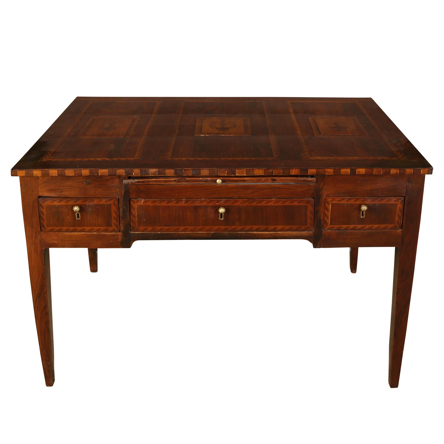 An exceptionally beautiful Italian writing table with three drawers and a leather top pull-out writing surface.  The desk is constructed in a walnut, with a lighter secondary wood.  Beautifully crafted, the desk features exquisite neoclassical motif