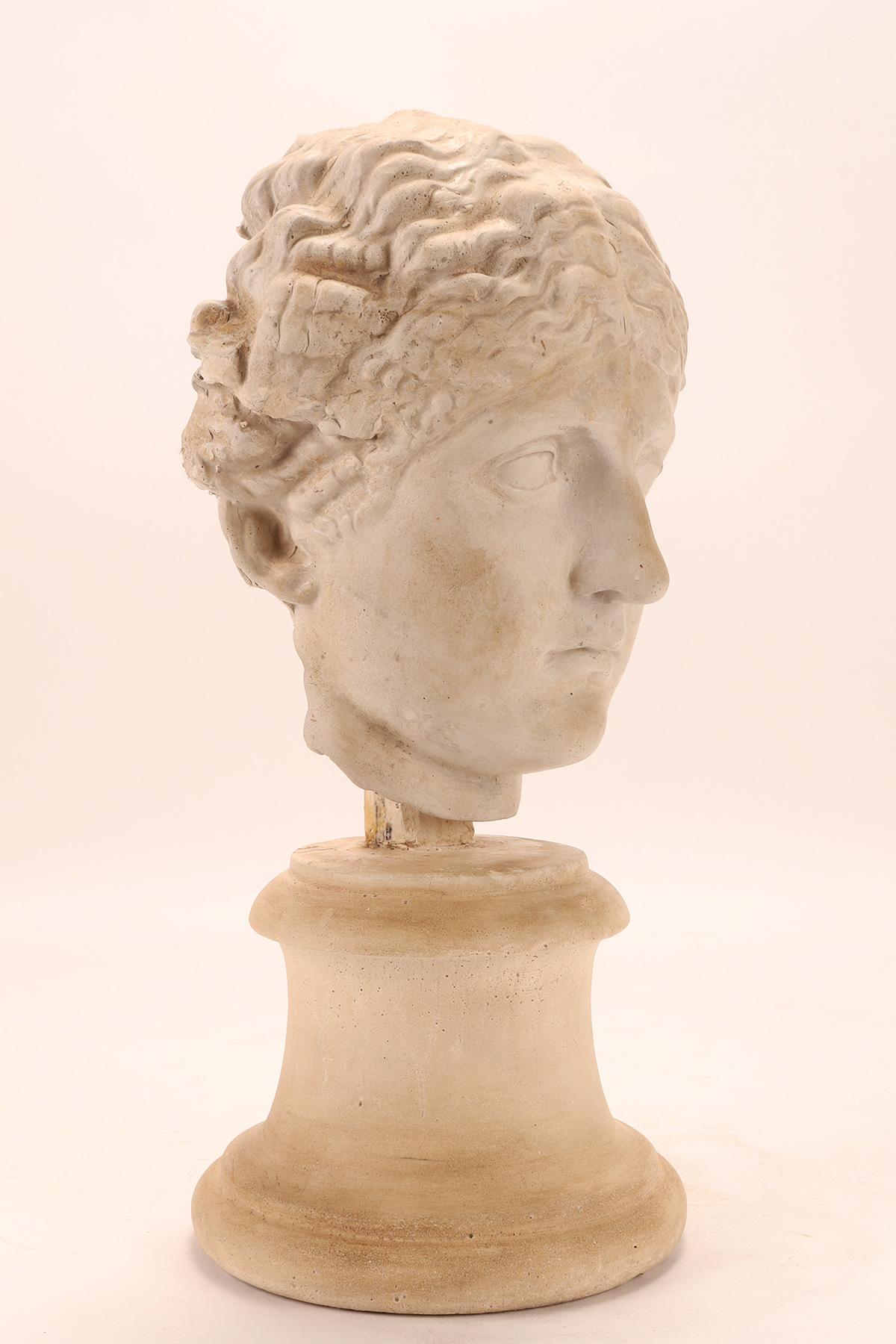 Above the plaster base, by means of a wooden support, the cast of the head of a Roman woman is set. Cast for the teaching drawing in the academy. Italy circa 1890.