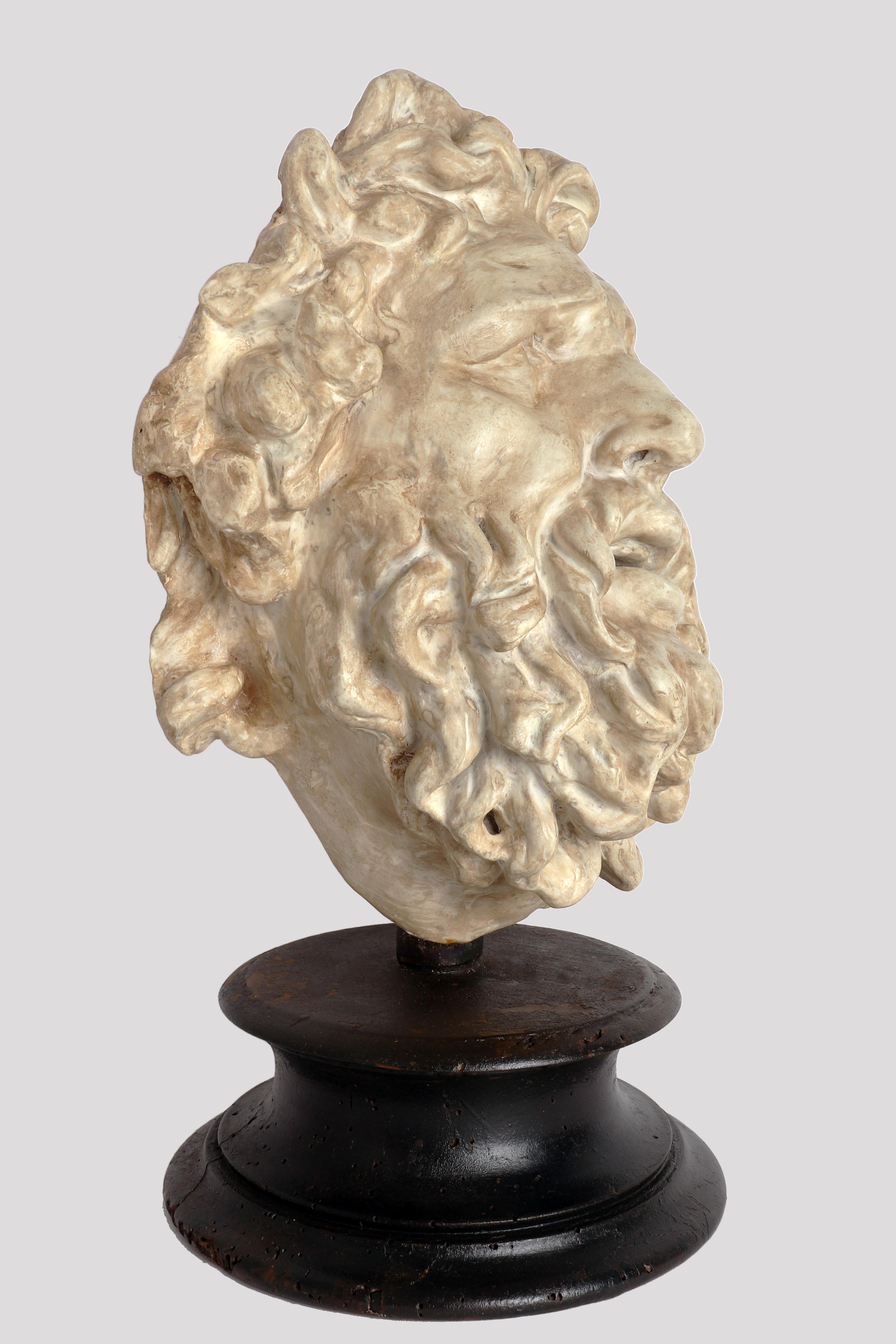 Auf dem schwarz bemalten Holzsockel ist der Gipsabdruck des jungen Kopfes von Laoconte mit Bart angebracht. Abguss für den Zeichenunterricht in der Akademie, Italien um 1880.