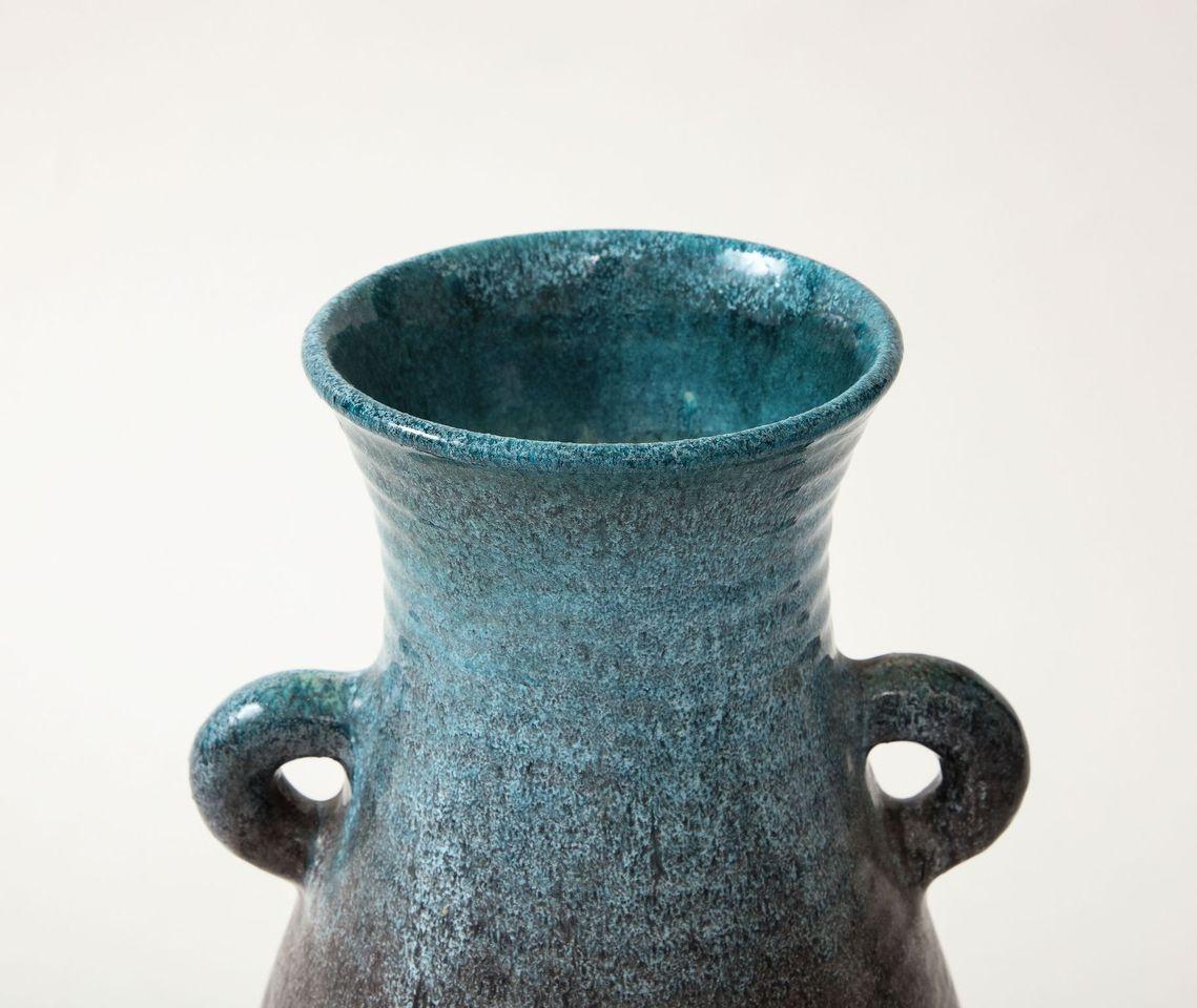 A ceramic jug with two handlesin a beautiful glaze of blue and aubergine produced by Accolay Pottery. Founded in the 1950s in Accolay, France, the Accolay studio became well known after it produced buttons for the collection of Christian Dior. One