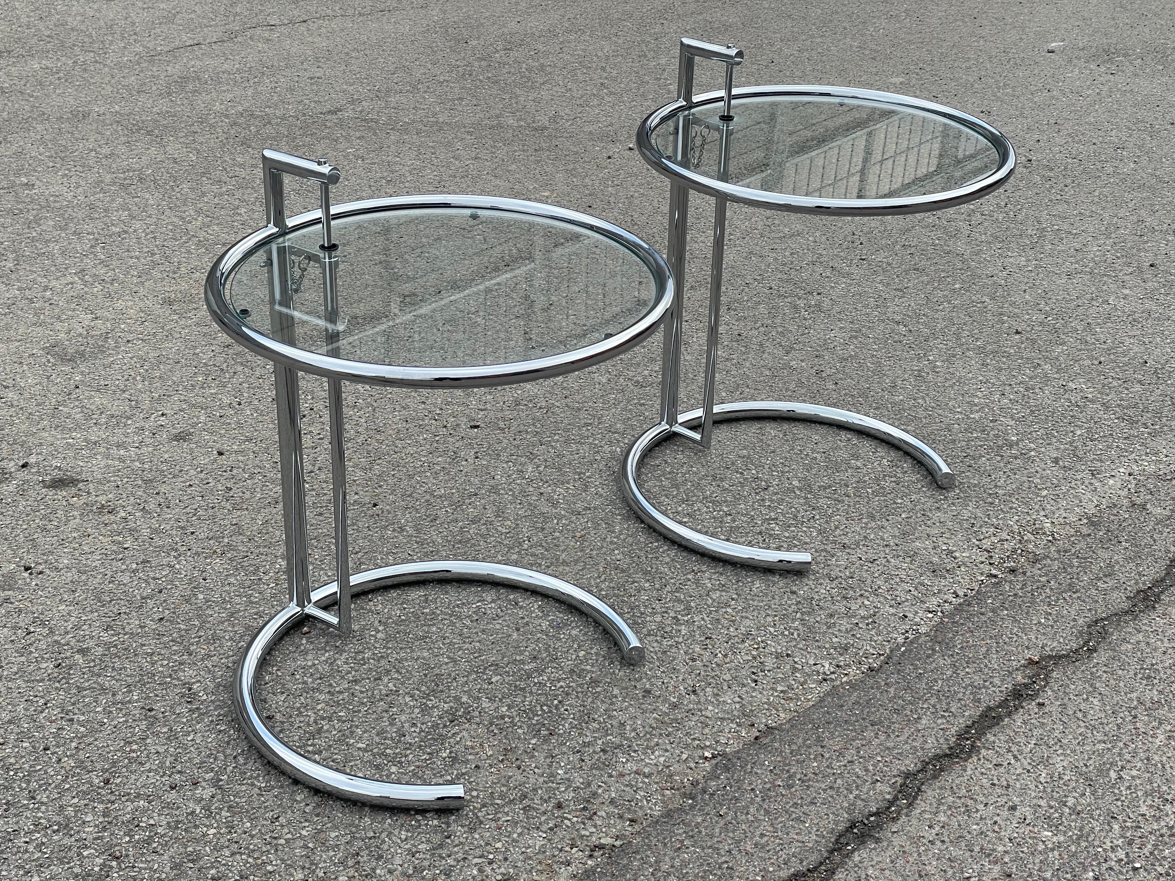 A Pair of adjustable Sidetables or night stands in chrome and glass in the style of Eileen Gray