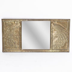 An Aesthetic Movement brass mirror with stylized peacocks perched on a branch