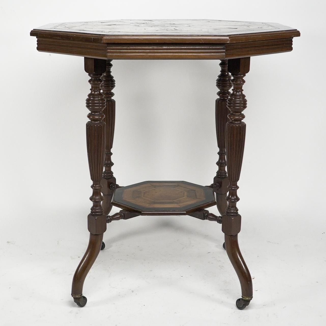 An Aesthetic Movement ebonized side table with a marquetry octagonal top decorated with conch shells and a central star detail in various fruit woods, with ebonized string and chequer inlays. Stood on turned and fluted legs united by a further