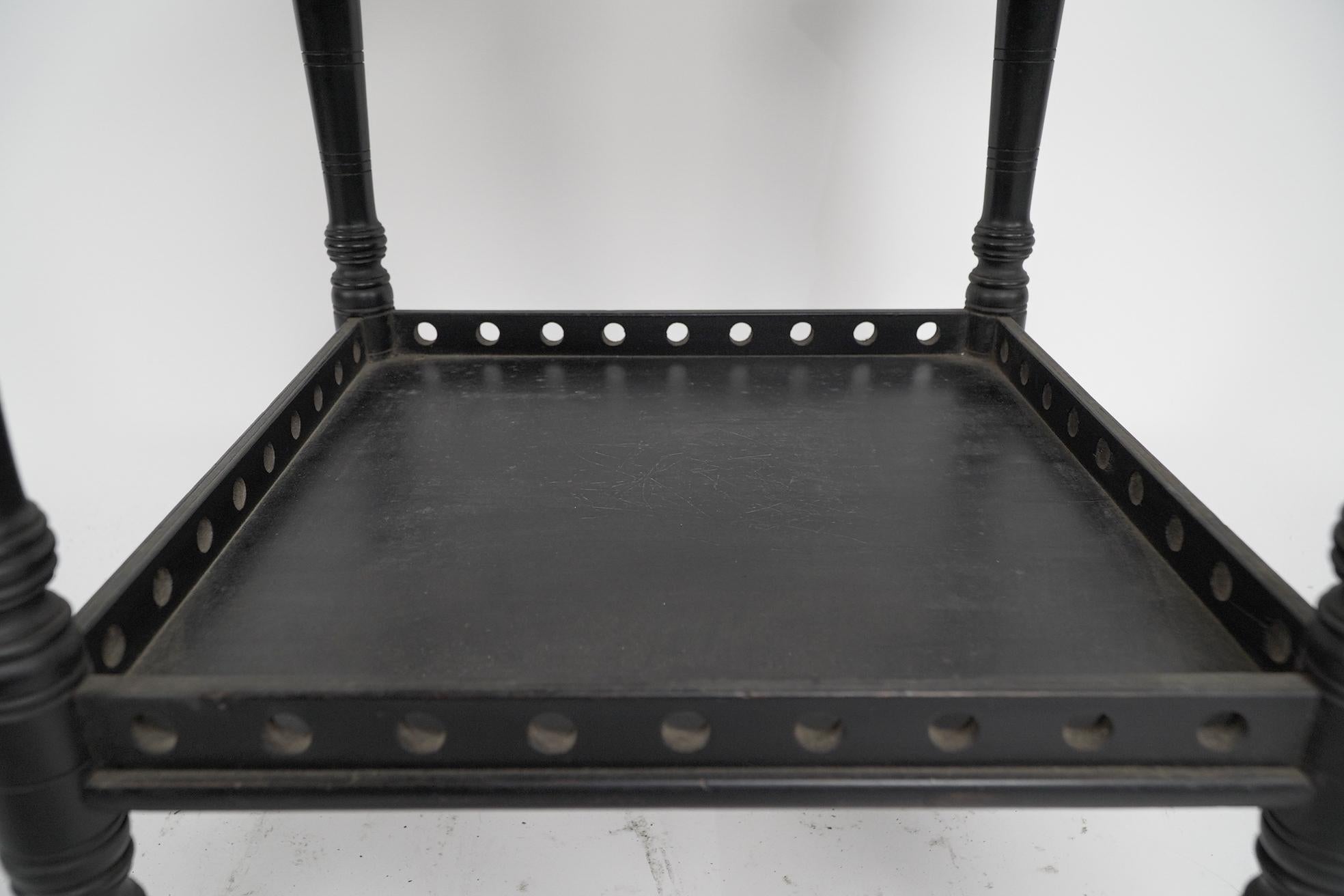 An Aesthetic Movement ebonized walnut two tier side table with a pierced gallery For Sale 3