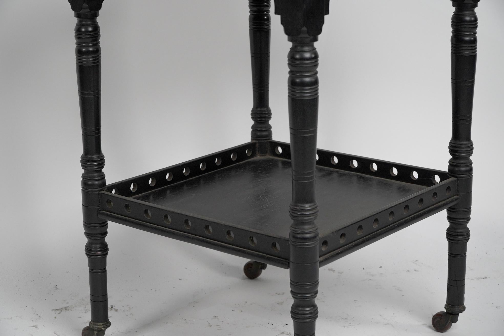 An Aesthetic Movement ebonized walnut two tier side table with a pierced gallery For Sale 5