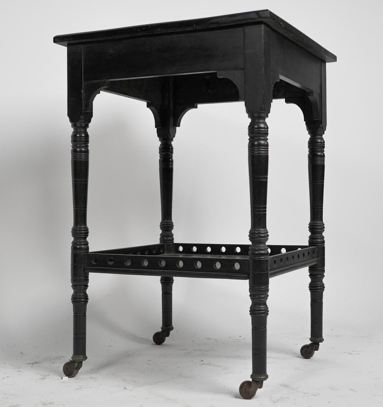 English An Aesthetic Movement ebonized walnut two tier side table with a pierced gallery For Sale