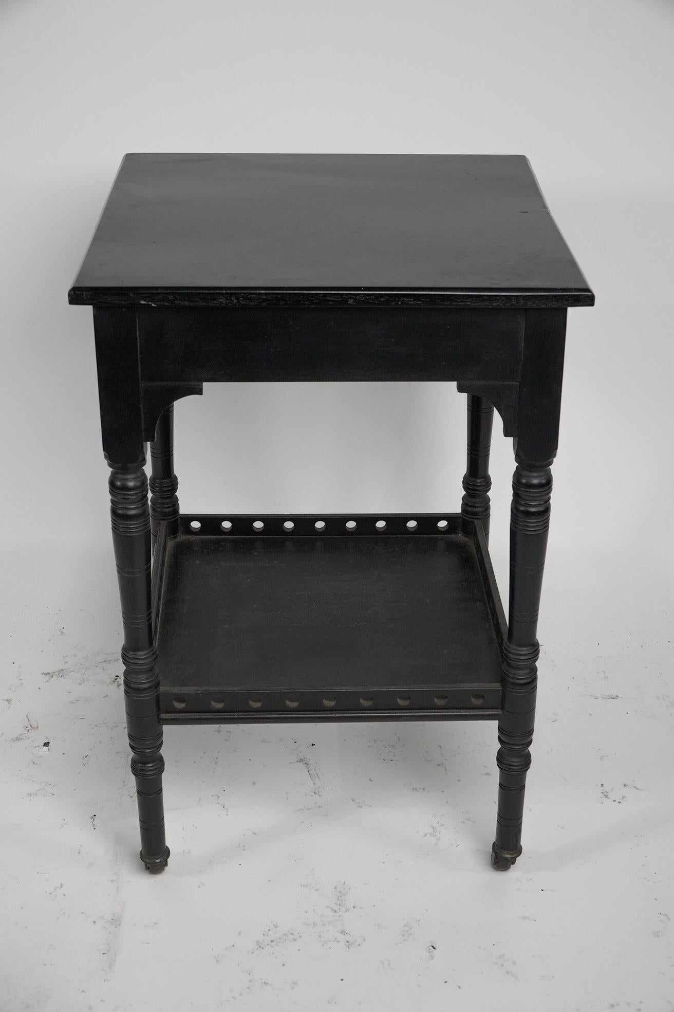 An Aesthetic Movement ebonized walnut two tier side table with a pierced gallery In Good Condition For Sale In London, GB