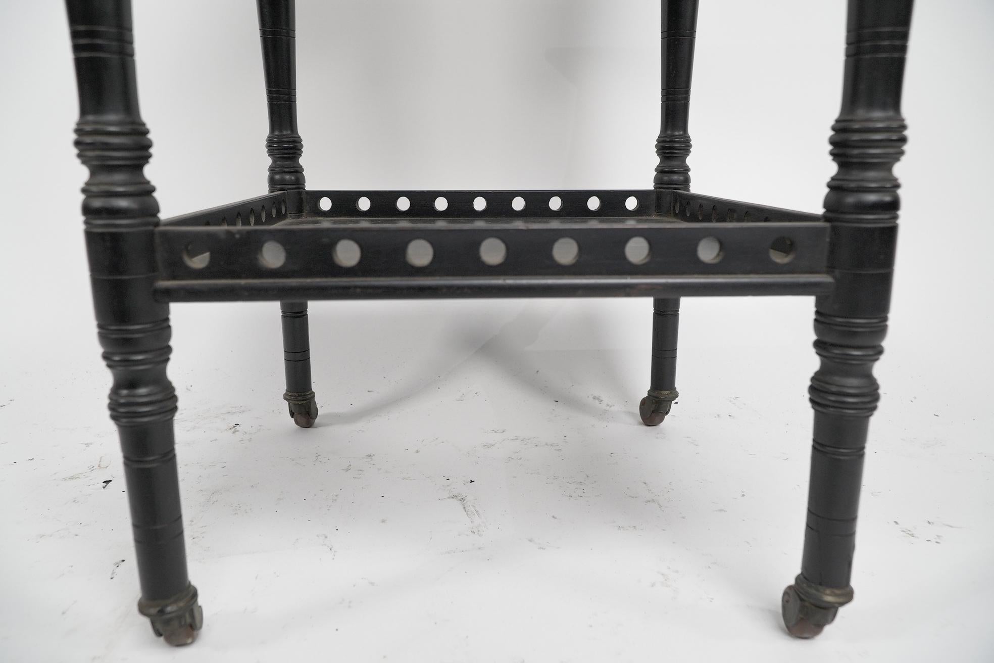 An Aesthetic Movement ebonized walnut two tier side table with a pierced gallery For Sale 4