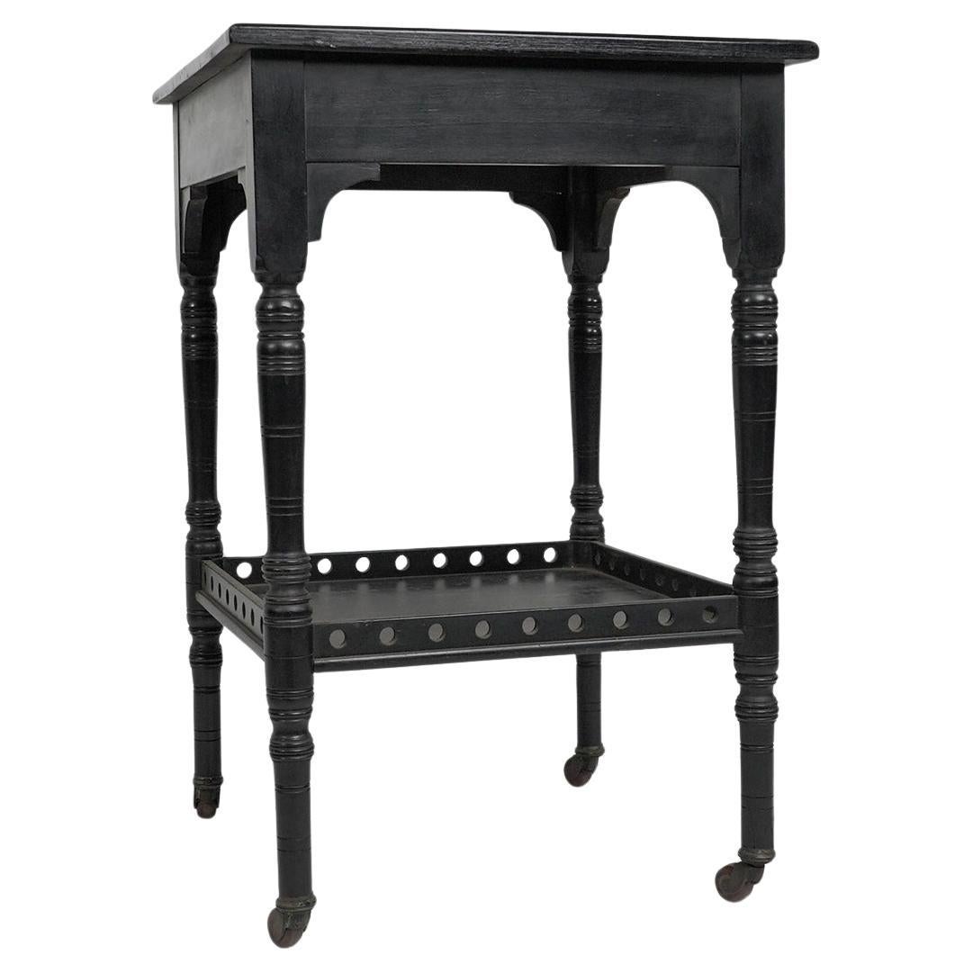 An Aesthetic Movement ebonized walnut two tier side table with a pierced gallery For Sale