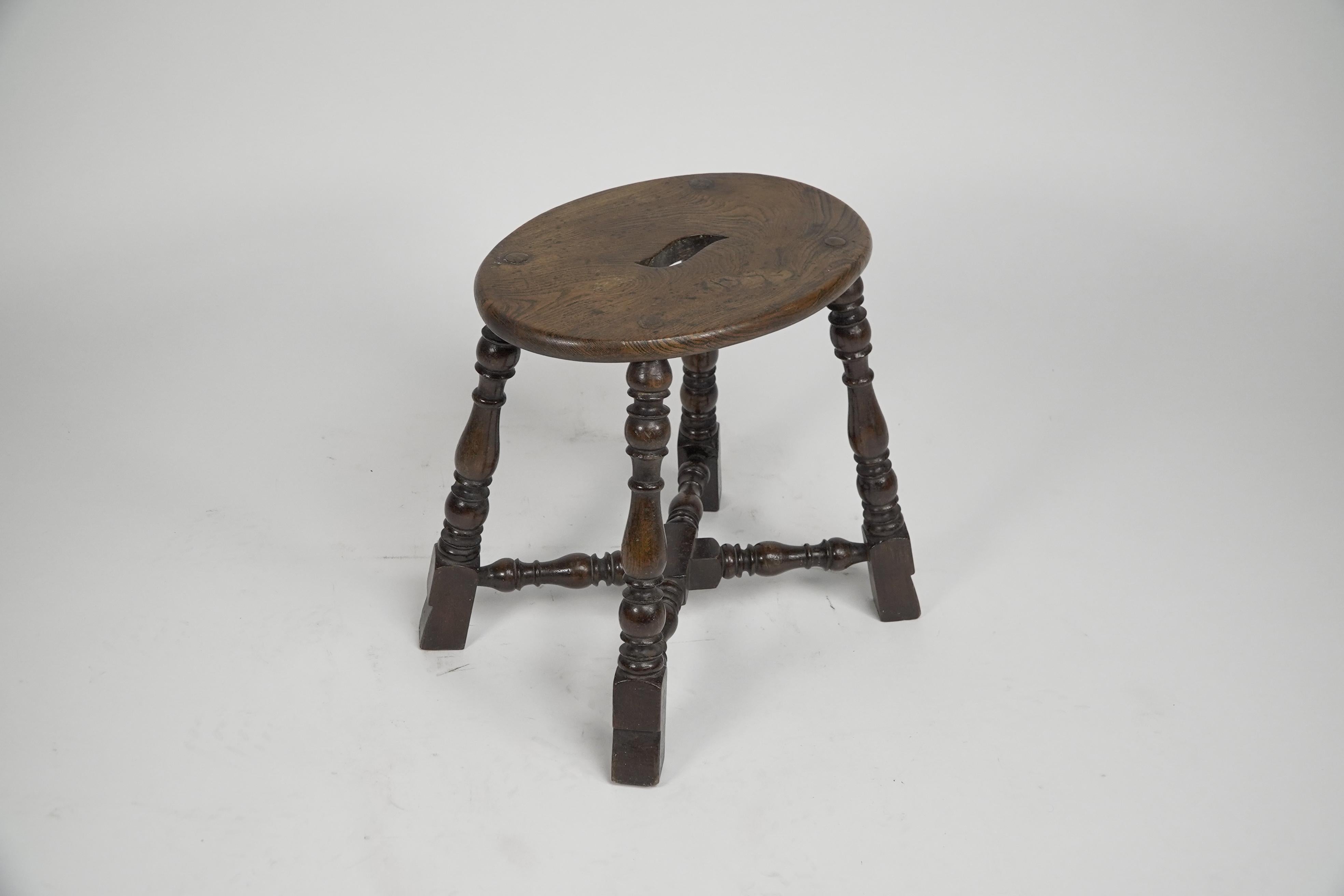 Late 19th Century An Aesthetic Movement Elm stool with a 'S' handle, and a wild grain to the seat. For Sale