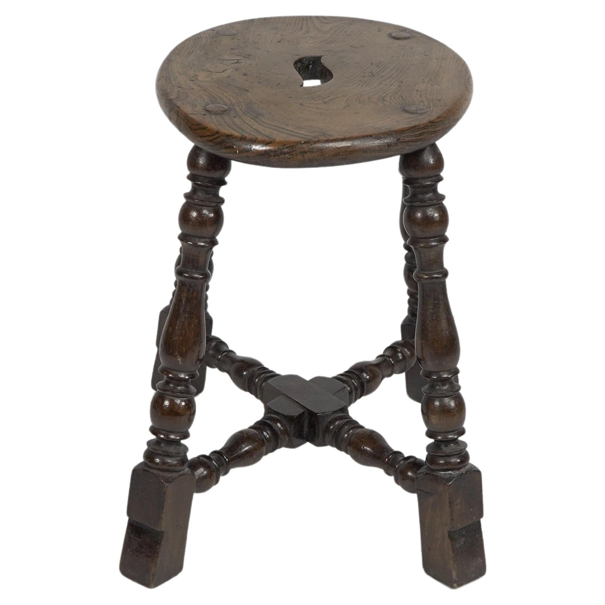 An Aesthetic Movement Elm stool with a 'S' handle, and a wild grain to the seat. For Sale