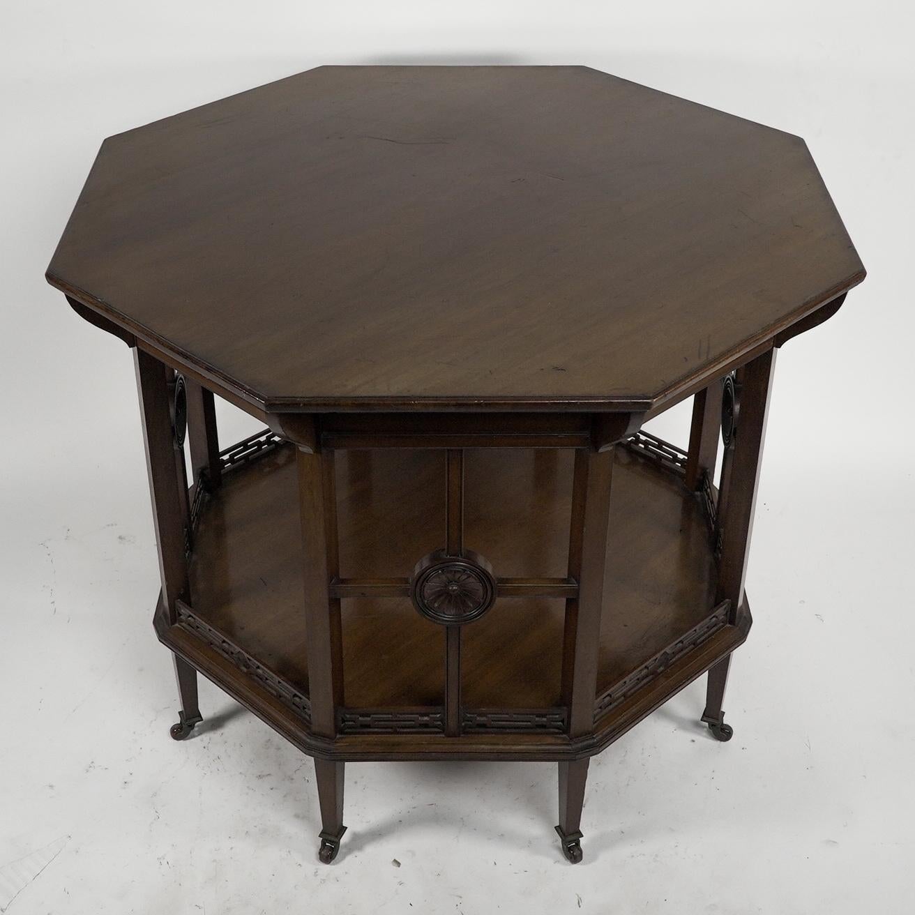 Gillows attributed, in the style of H W Batley. An Aesthetic Movement octagonal Mahogany eight leg centre table with shaped supports below the top and four open sides below with four cross supports centred by carved florets uniting to the lower