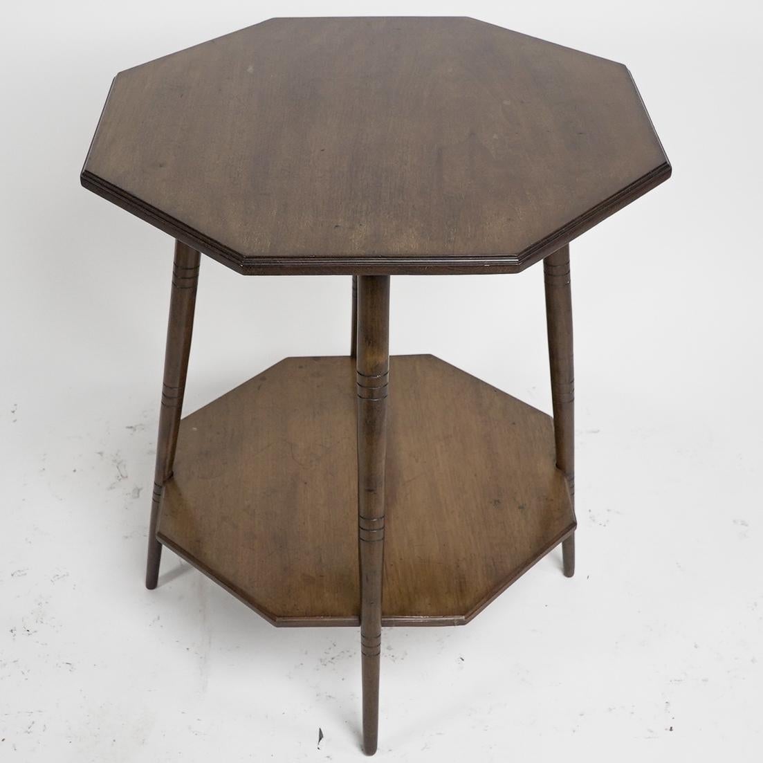 Collinson & Lock attributed. An Aesthetic Movement Walnut octogonal two tier side table on splayed and fine ring turn legs, reminiscent of some of the legs Godwin chased around.
