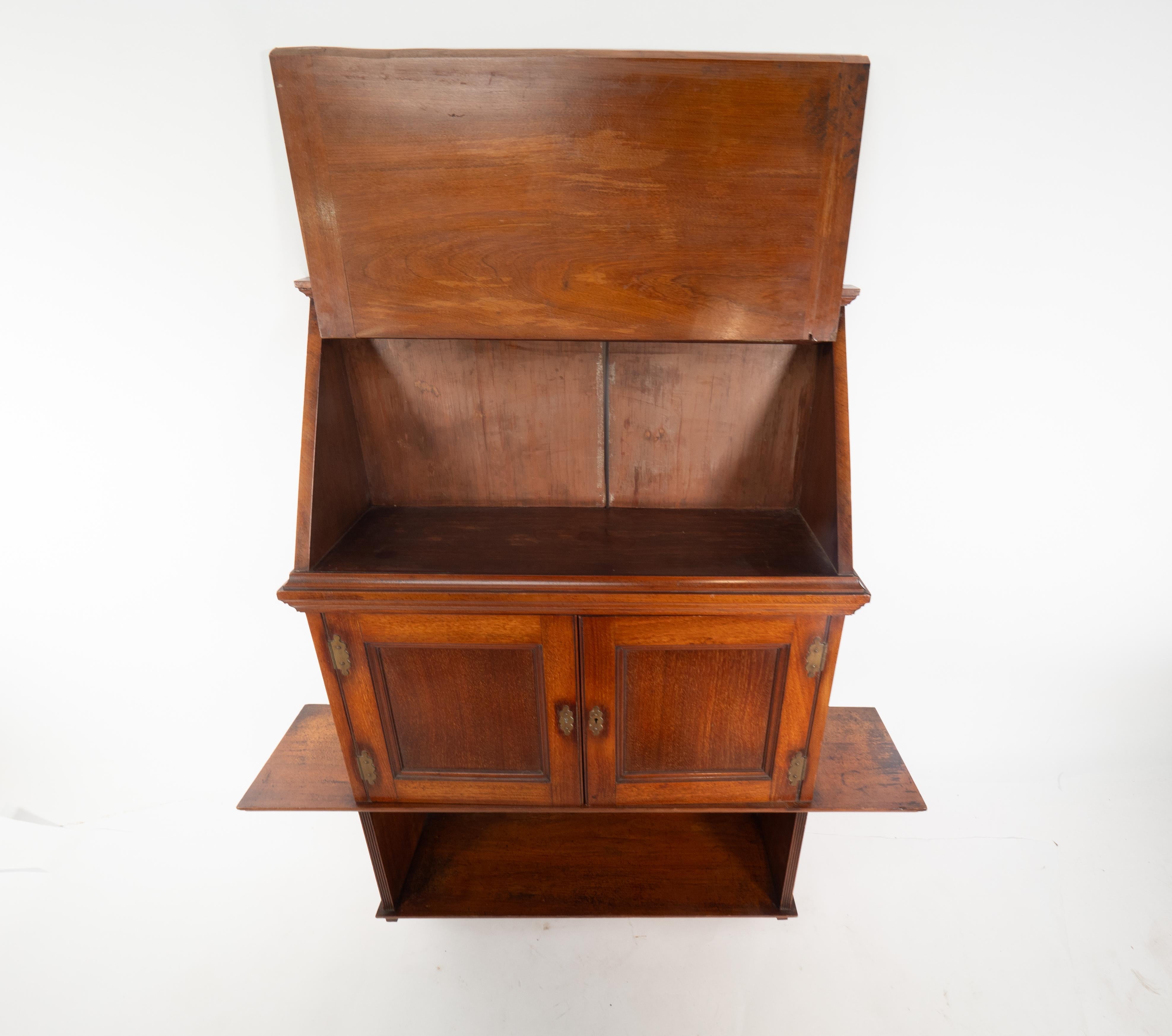 E W Godwin-Stil, möglicherweise von Edwards und Roberts hergestellt. Ein Regalset aus Nussbaumholz mit abgewinkeltem Schrank und Tür oben, einem zweitürigen Schrank unten mit Messinggriffen und -scharnieren und ausziehbaren Seitenregalen mit einem